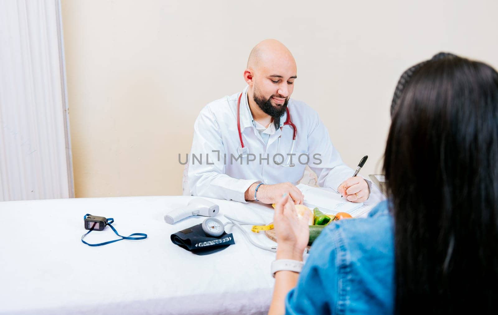 Nutritionist man giving consultation to woman patient in office, Woman patient receiving consultation from nutritionist. Smiling nutritionist explaining to a female patient