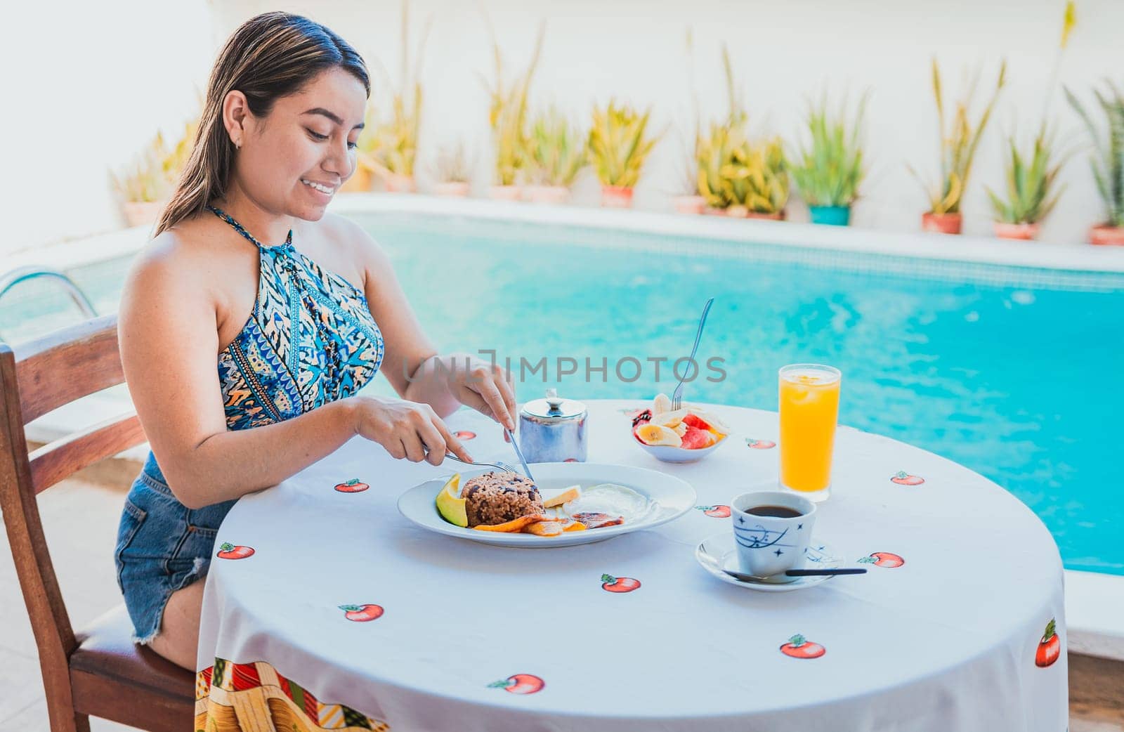 Woman on vacation having breakfast near swimming pool. Breakfast concept near swimming pool, Smiling girl having breakfast near the swim pool