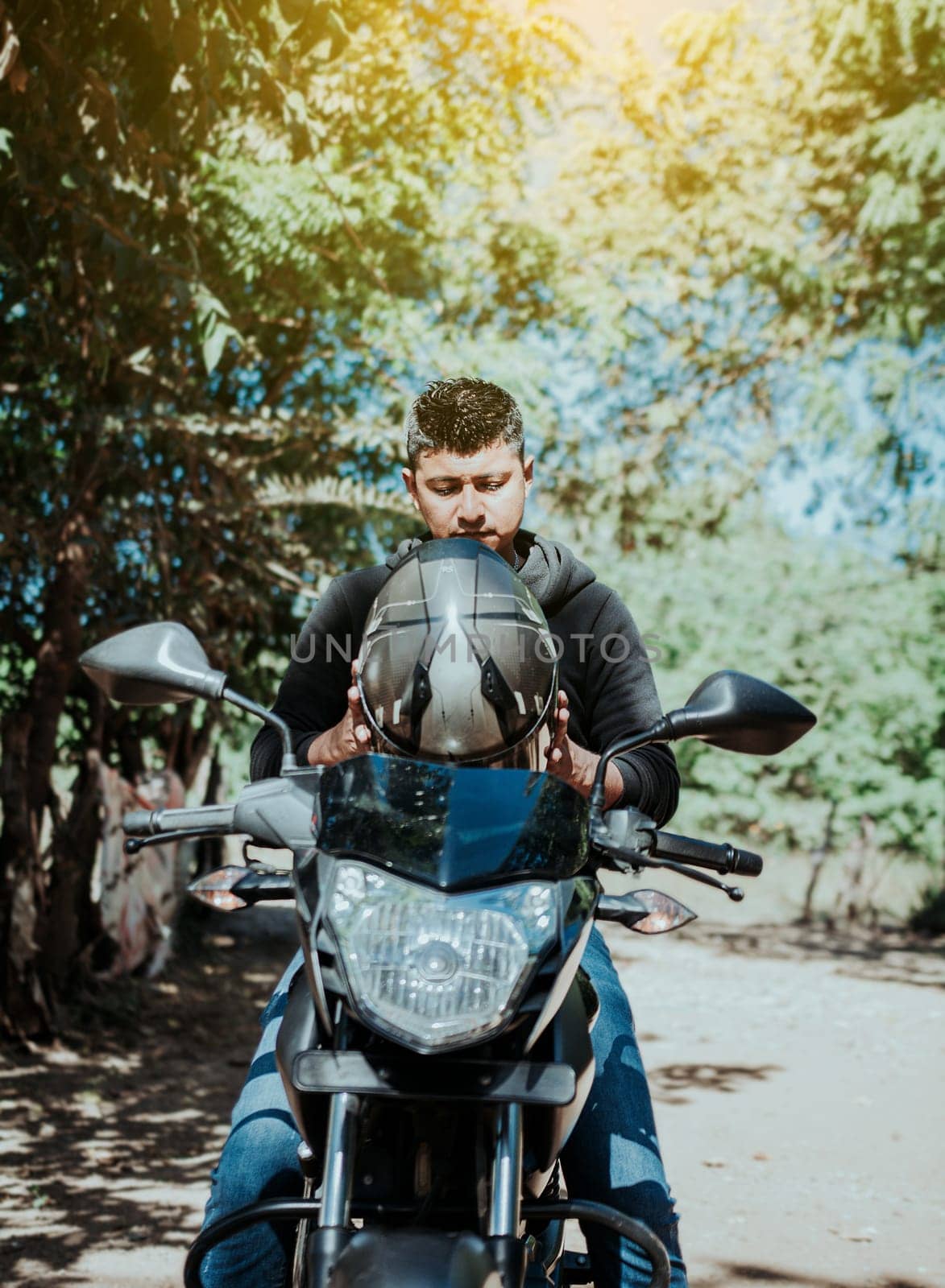 Motorcyclist putting on safety helmet, Biker motorcycle safety concept. Young motorcyclist man putting on safety helmet, Man on motorcycle putting on helmet