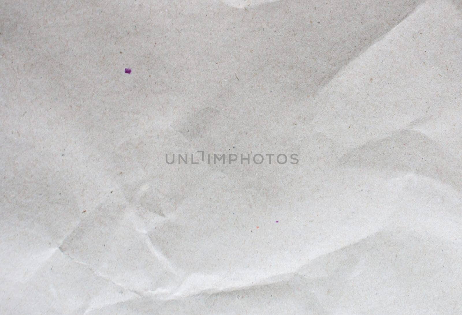 Cardboard background made of natural crumpled gray paper.