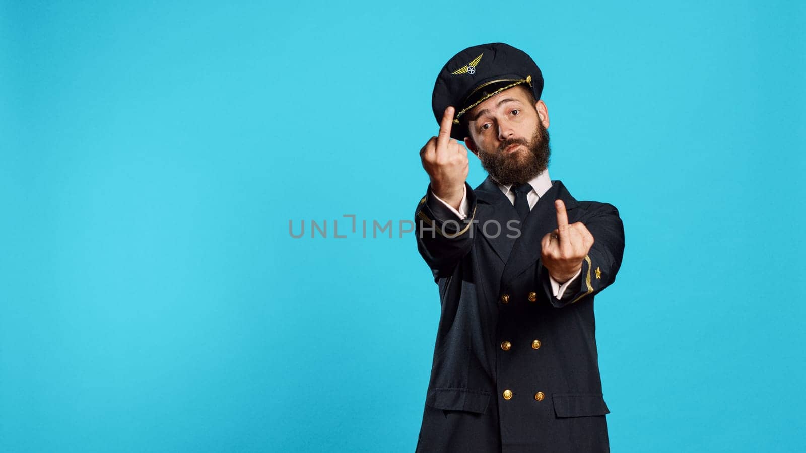 Caucasian airline captain showing middle fingers by DCStudio