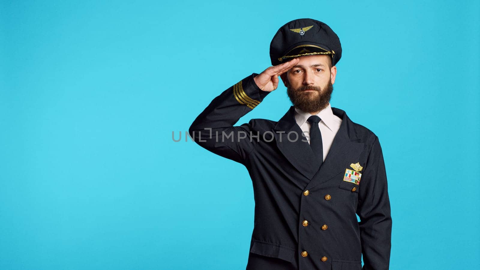 Male model wearing pilot uniform and hat on camera by DCStudio