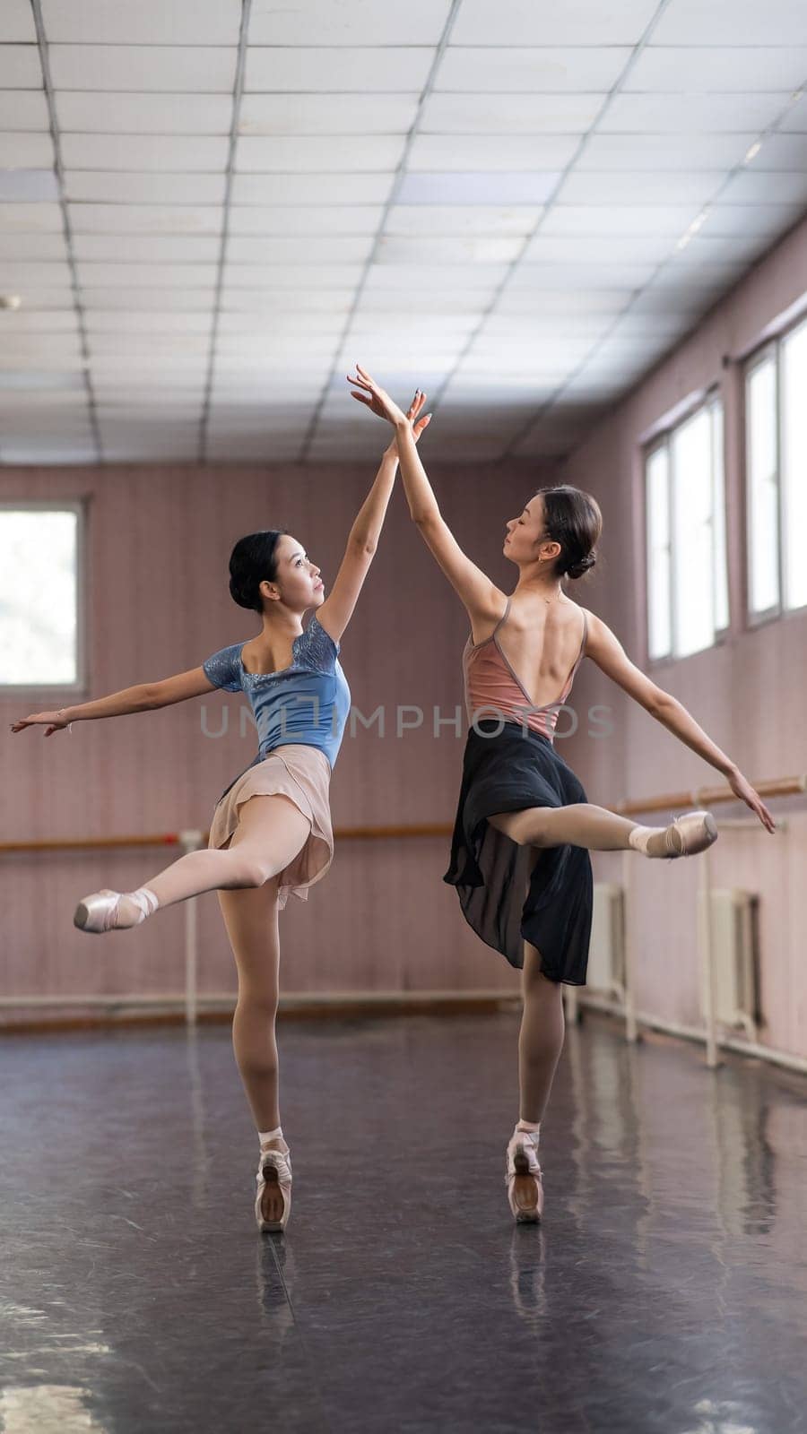 Two Asian ballerinas are dancing in the class. by mrwed54