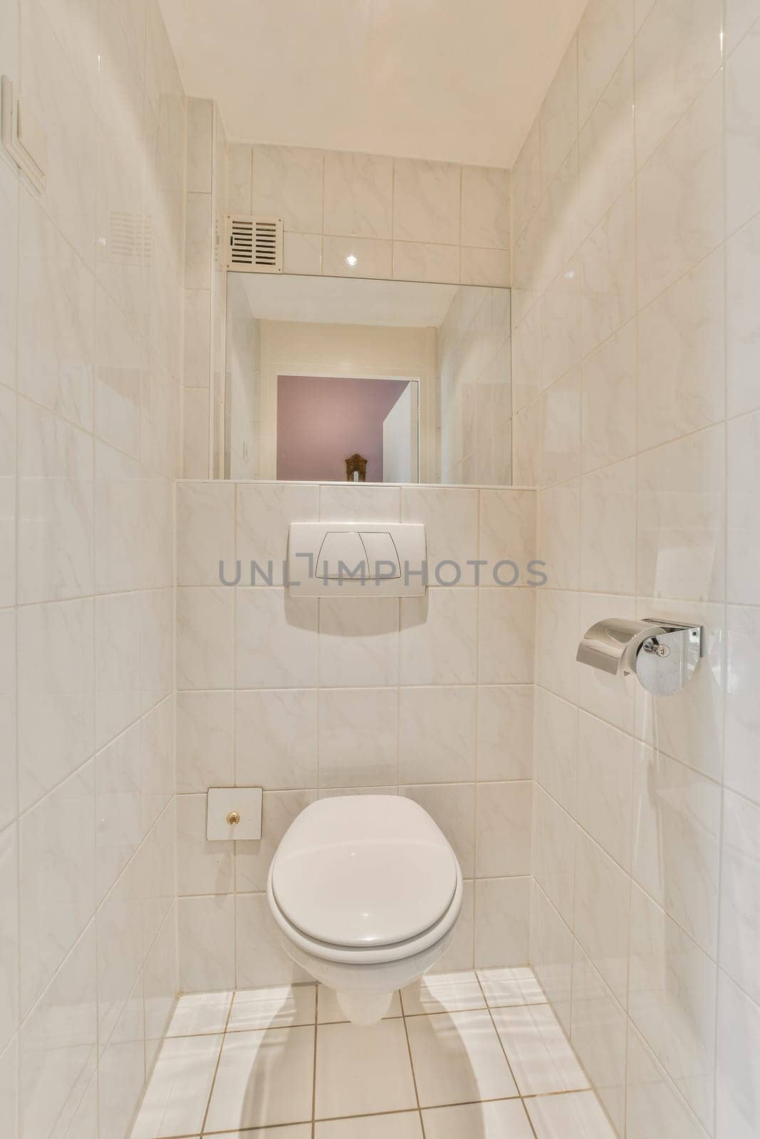 a white toilet in a bathroom with tile flooring and wall mounted mirror above the toilet is an image of a woman's reflection