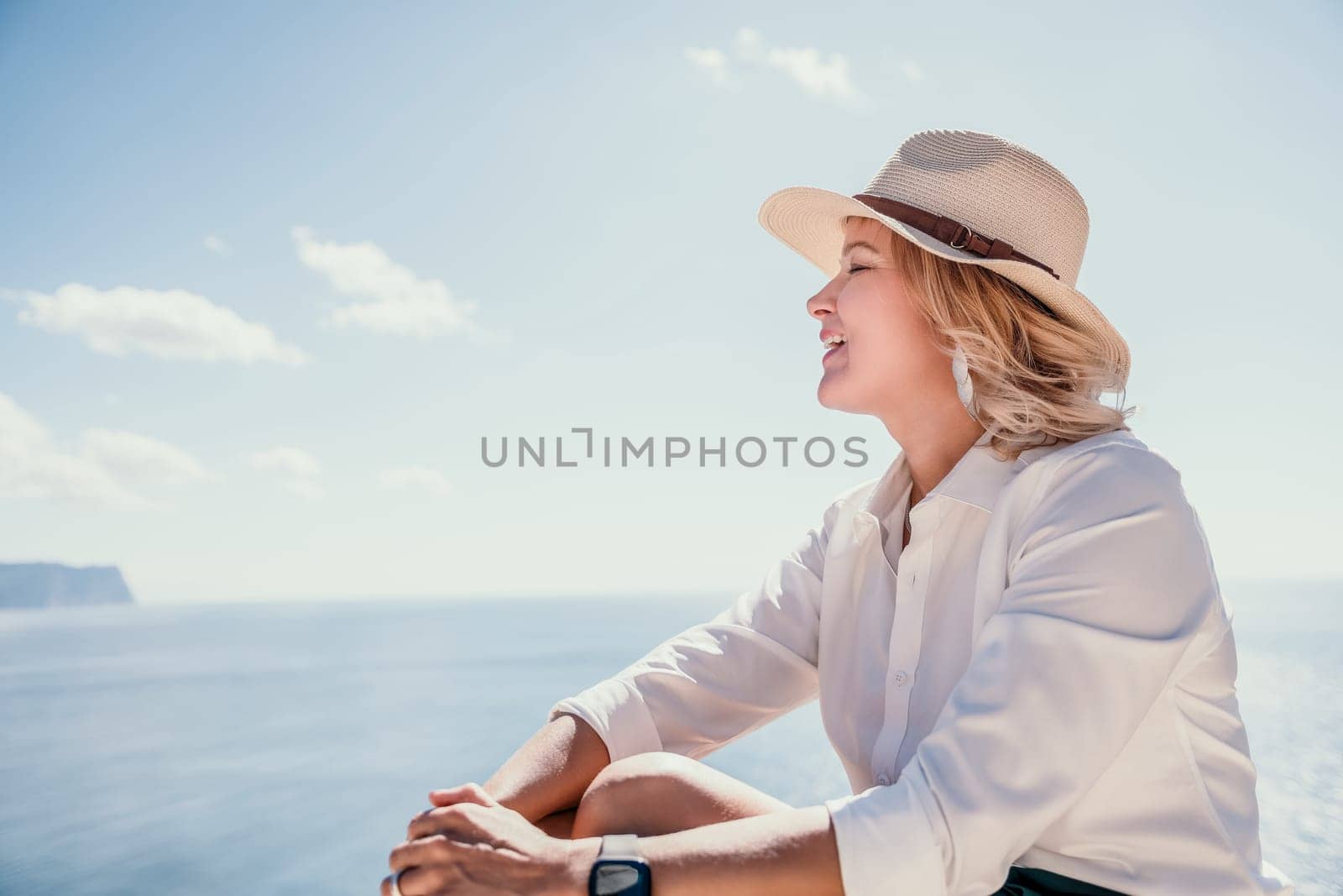 Woman sea laptop. Business woman in yellow hat freelancer with laptop working over blue sea beach. Girl relieves stress from work. Freelance, digital nomad, travel and holidays concept by panophotograph