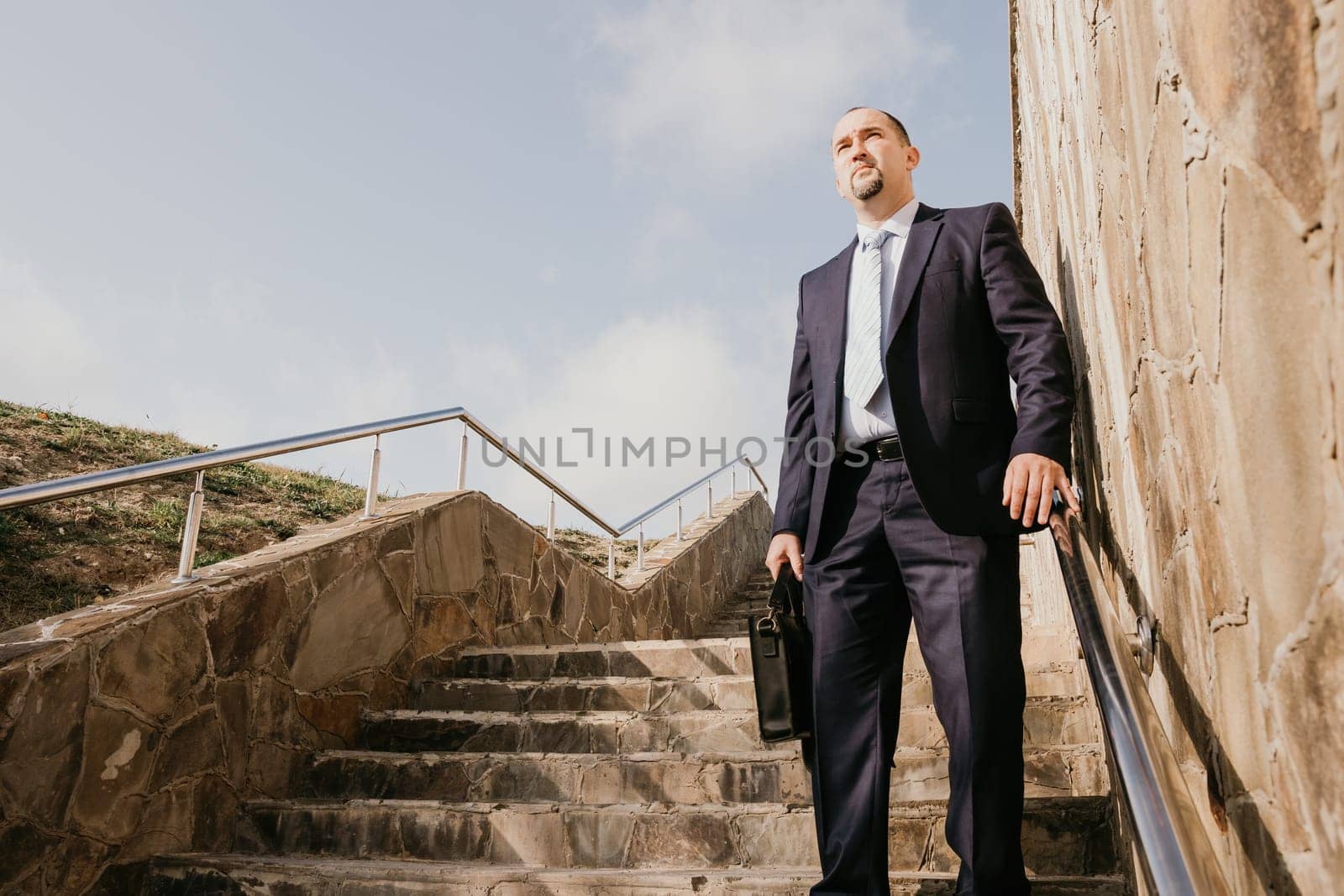 Business executive with briefcase going down the stairs.