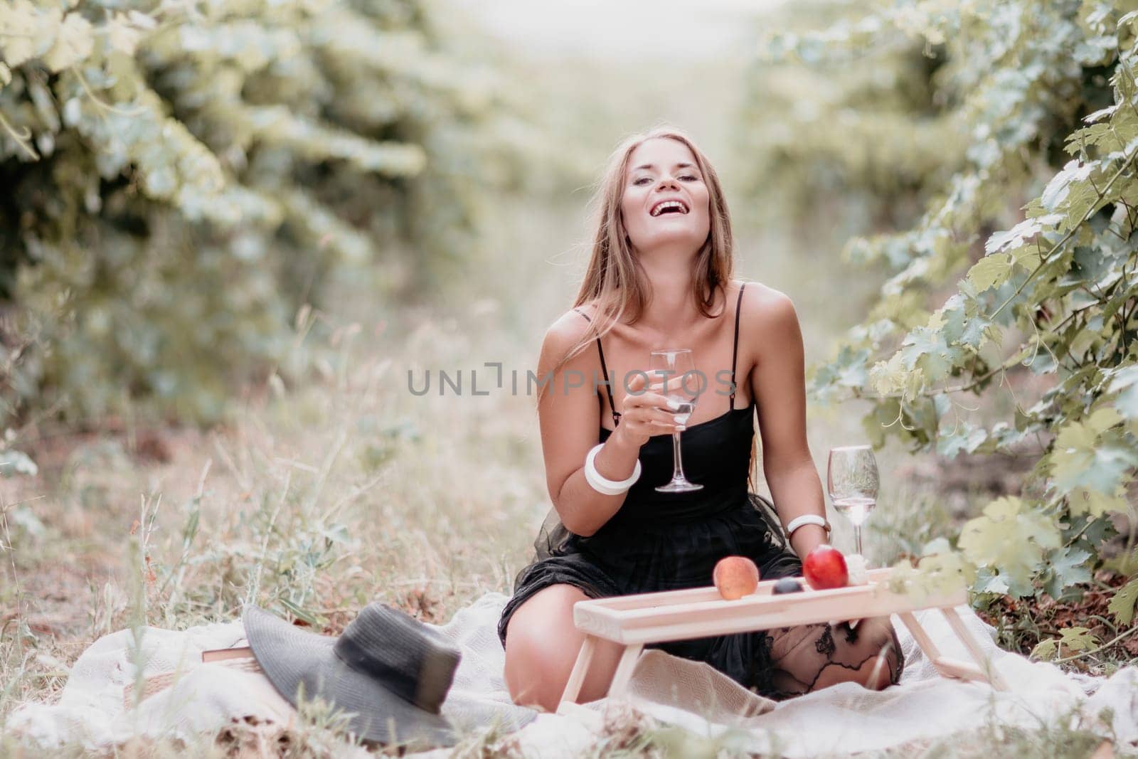 Picnic and wine tasting at sunset in the hills of Italy, Tuscany. Vineyards and open nature in the summer. Romantic dinner, fruit and wine.