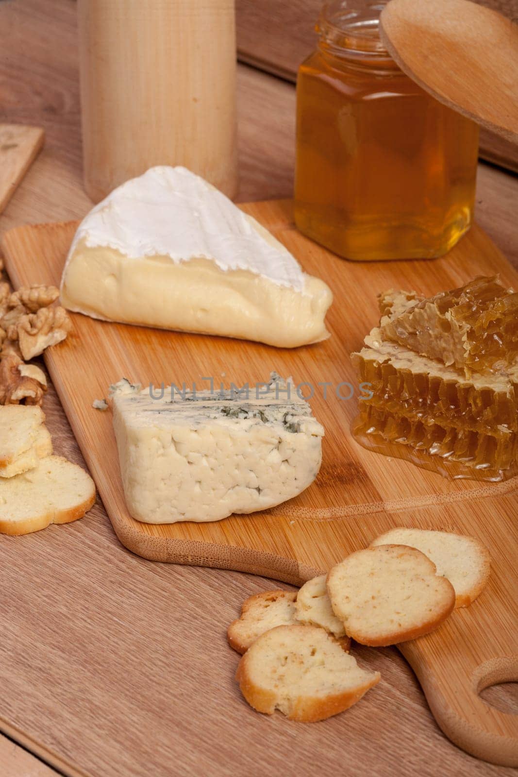 Dor blue and white cheese with nuts and honey on vintage wooden background in studio photo