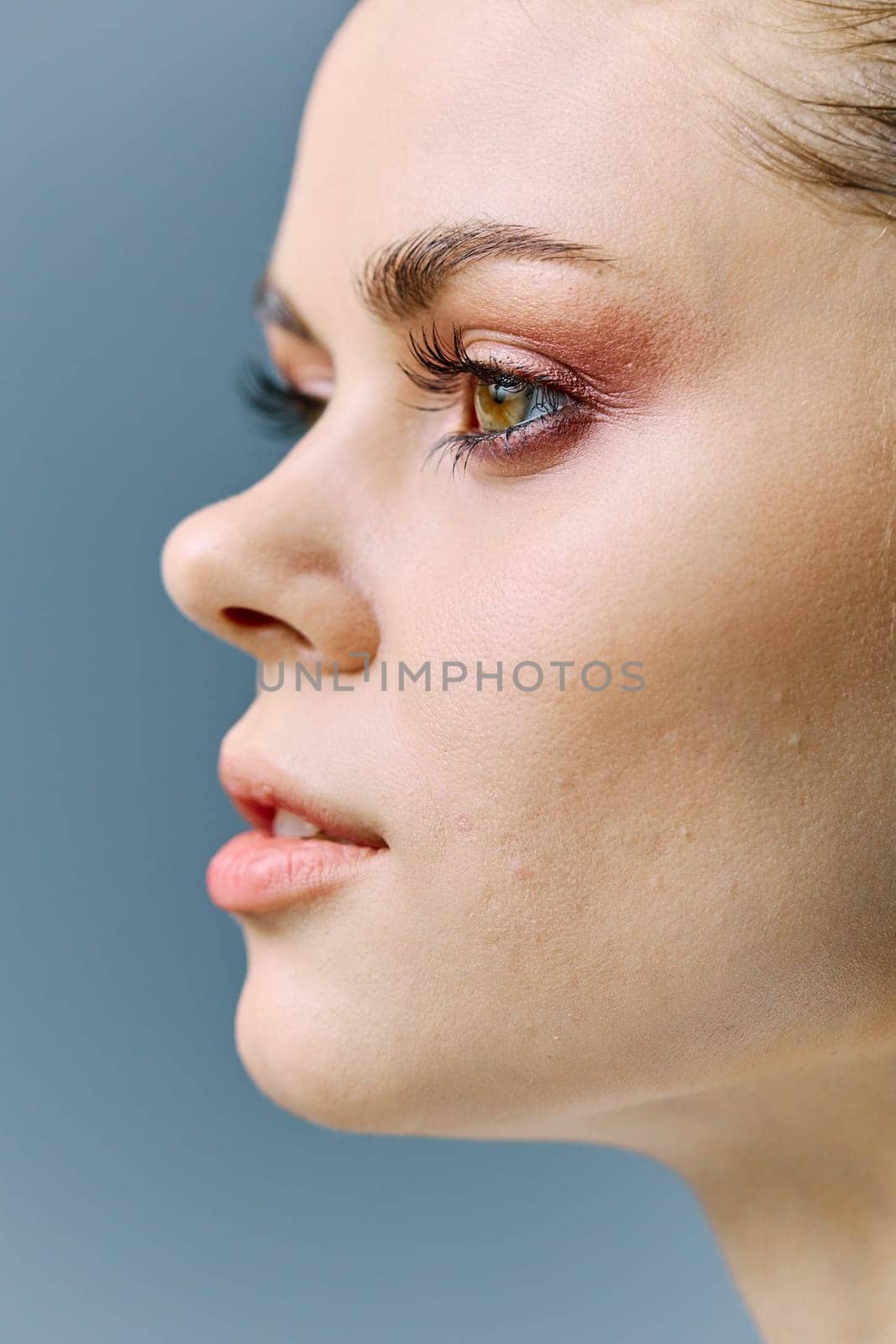a close vertical portrait of a beautiful woman with neat evening makeup, and problematic skin, standing looking to the side. A photo from the fashion world without retouching by Vichizh