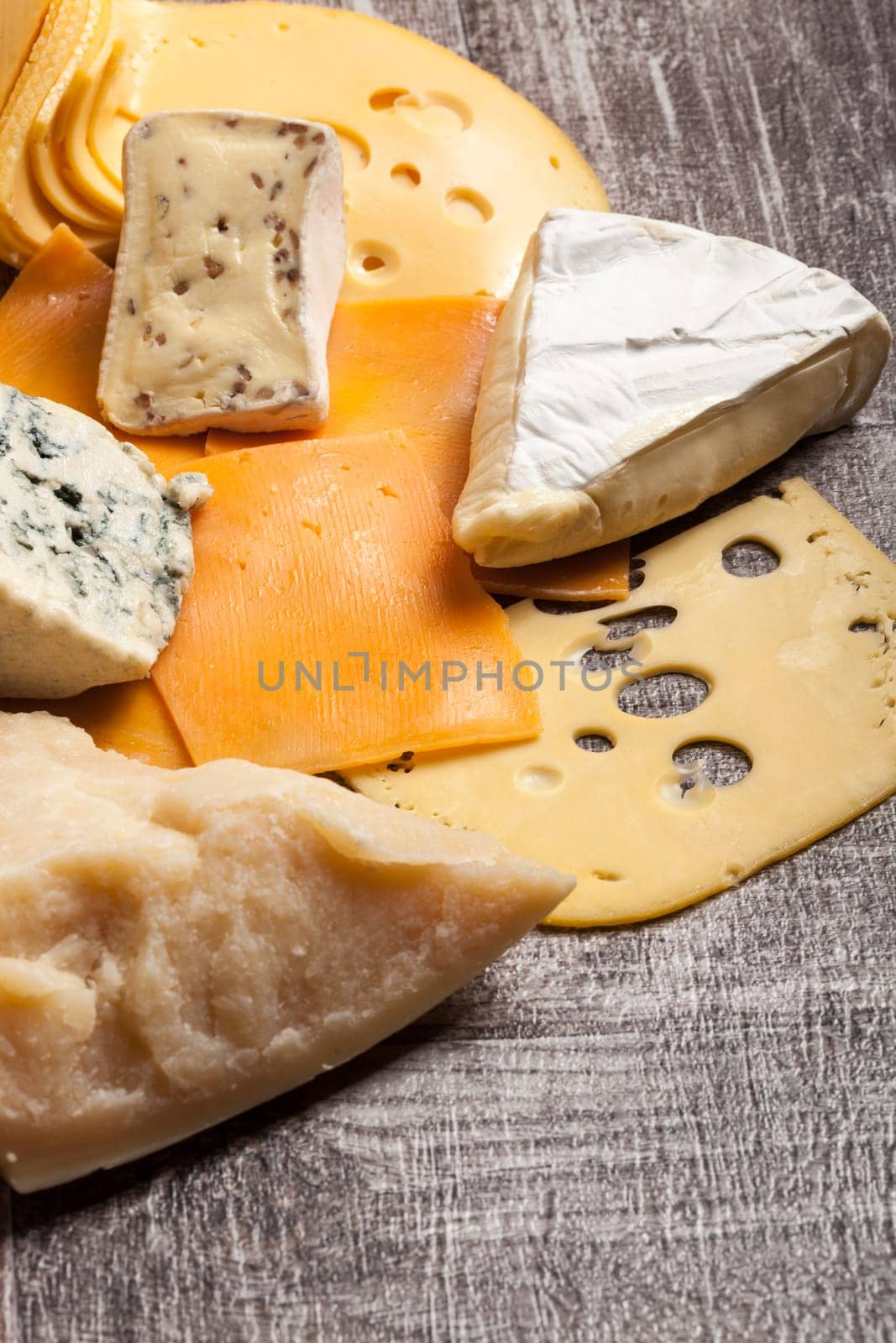 Different type of cheese on wooden background by DCStudio