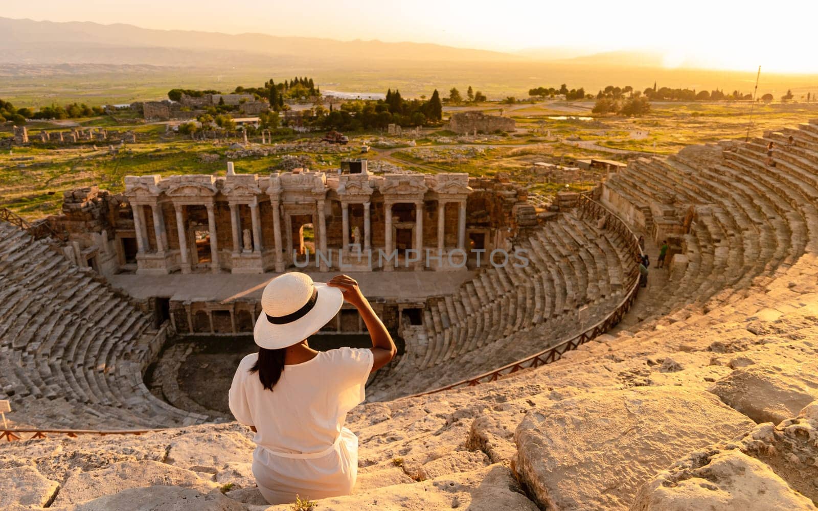 Hierapolis ancient city Pamukkale Turkey, sunset by the ruins Unesco site, Hierapolis ancient city Pamukkale Turkey Young Asian women with hat watching the sunset at Hierapolis Pamukkale