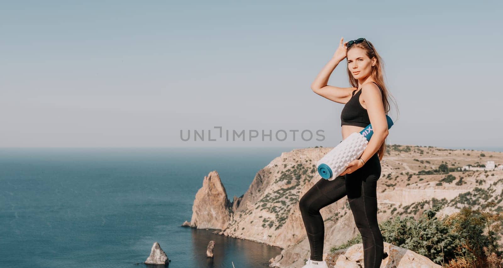 Fitness woman sea. Outdoor workout on yoga mat in park near to ocean beach. Female fitness pilates yoga routine concept. Healthy lifestyle. Happy fit woman exercising with rubber band in park.