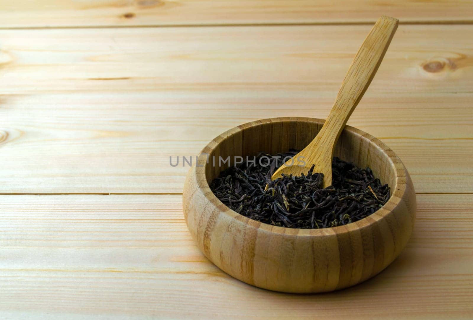 Leaf dry green tea. Leaf dry green tea in a wooden plate on a wooden table.