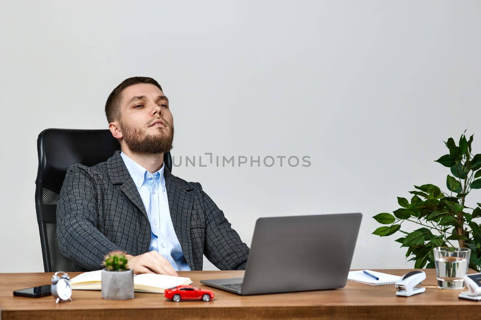 young man sitting on chair at table and resting, using laptop