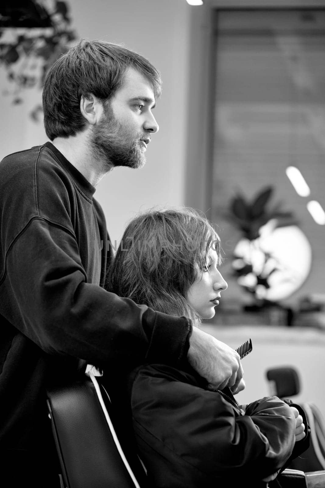 male hairdresser working with client at hair salon by erstudio