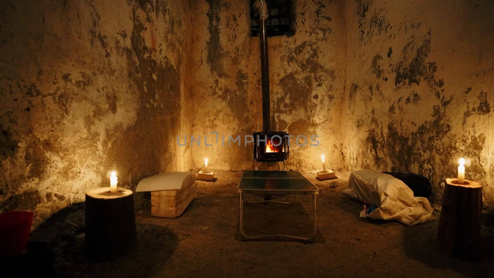 We made dumplings in field conditions. Cooking in an unusual place, in an old hut. There is a fire burning in the camp stove, candles next to the old walls. There are molded dumplings in flour