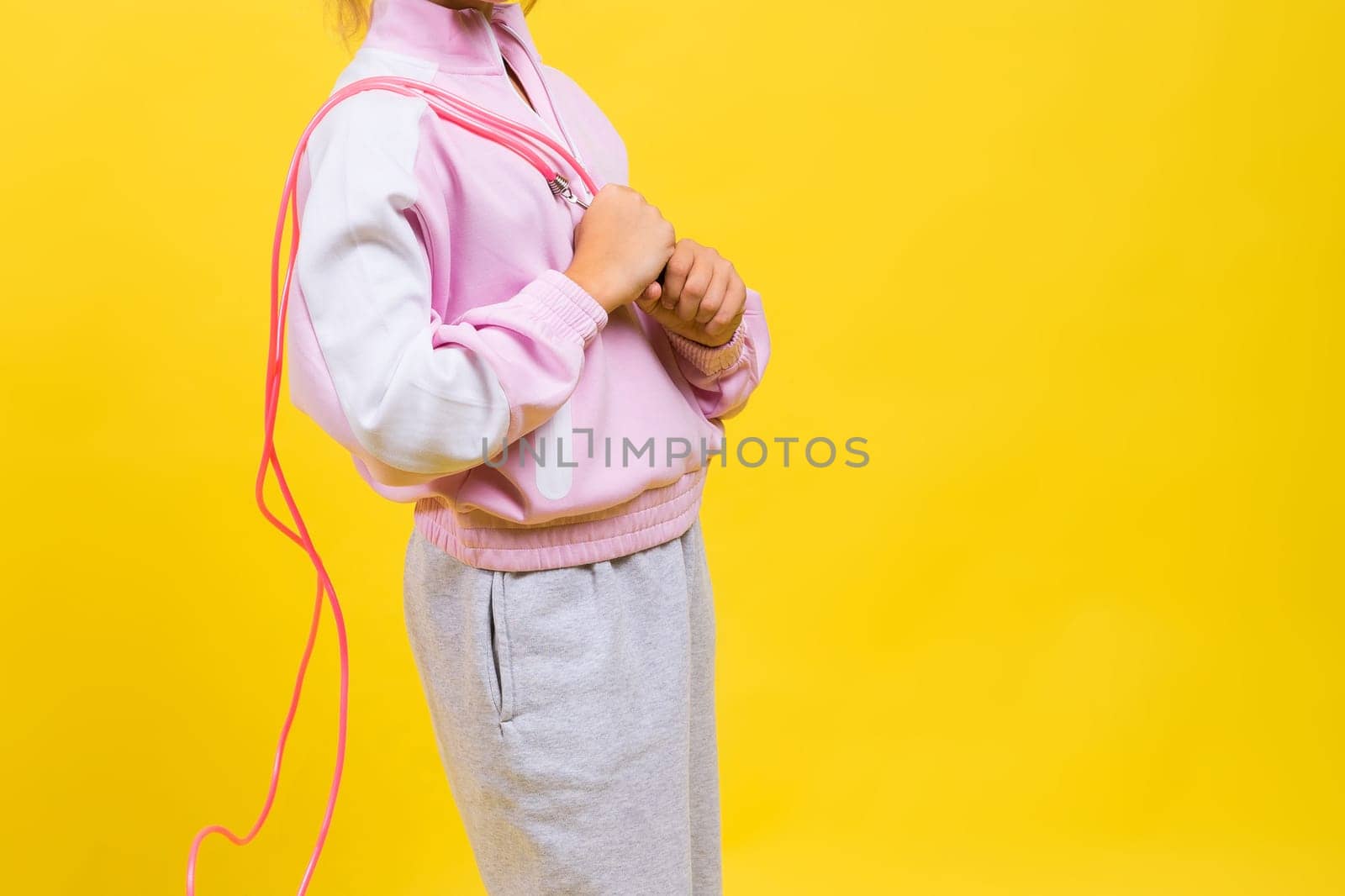 Adorable female child with skipping rope jumping in a studio