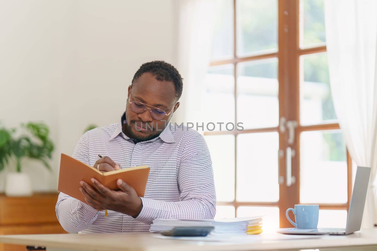 Smiling American African Banker or Accountant makes financial report and studies annual figures, analyzes profits. Accountant checks status of financial.