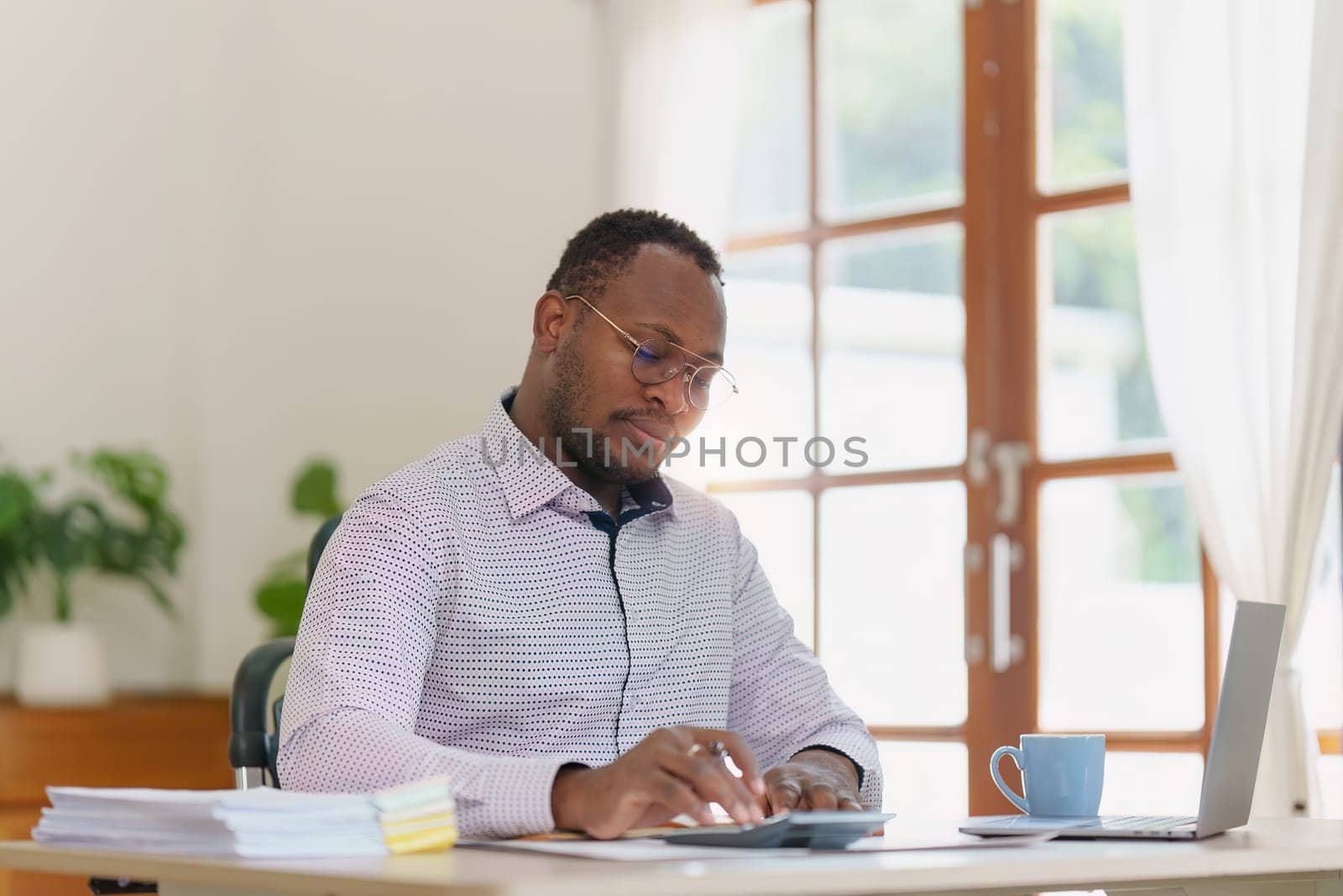 Smiling American African makes financial report and studies annual figures, analyzes profits. Accountant checks status of financial.