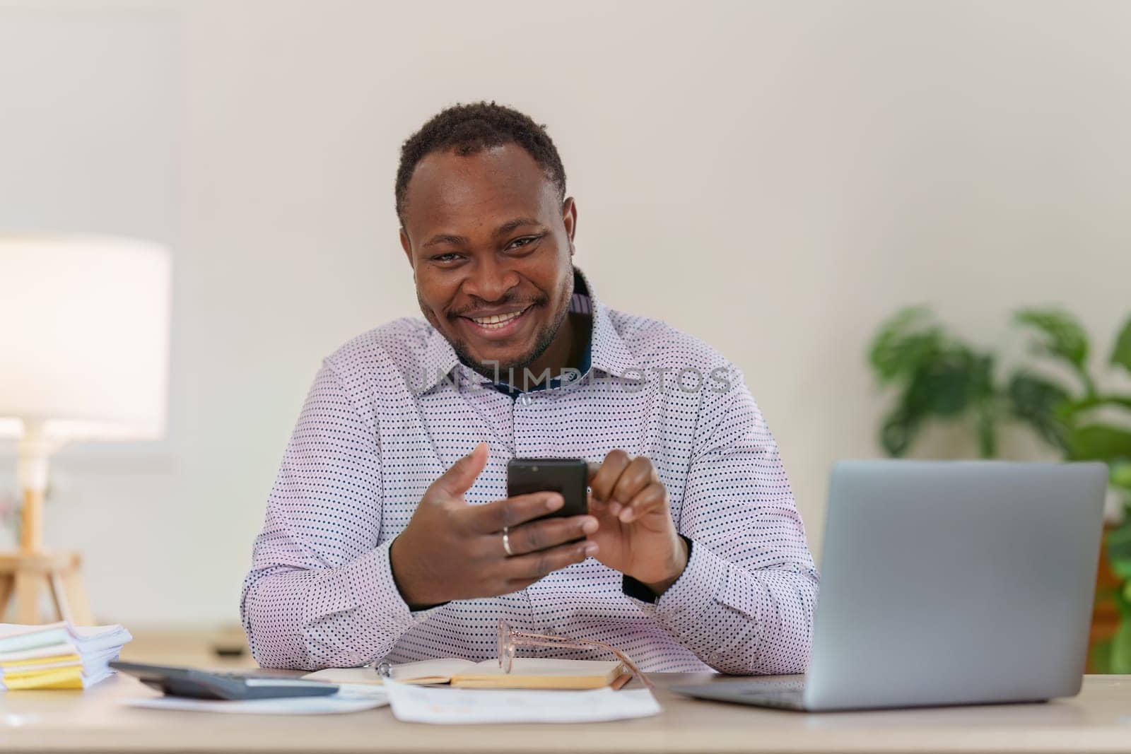 Smiling American African Banker or Accountant makes financial report and studies annual figures, analyzes profits. Accountant checks status of financial.