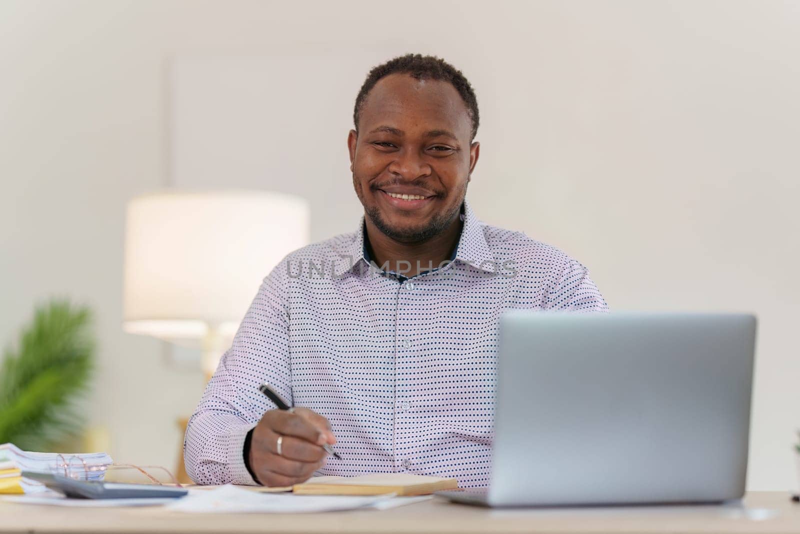 Smiling American African makes financial report and studies annual figures, analyzes profits. Accountant checks status of financial by itchaznong