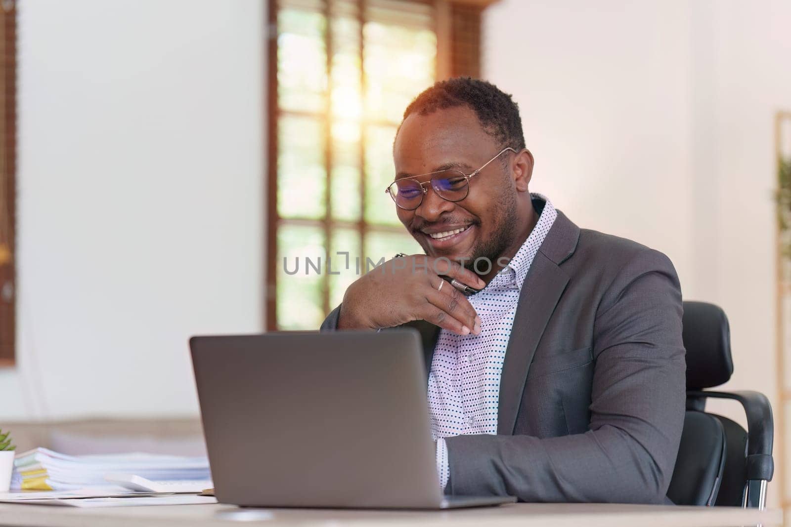 Smiling American African Banker or Accountant makes financial report and studies annual figures, analyzes profits. Accountant checks status of financial by itchaznong