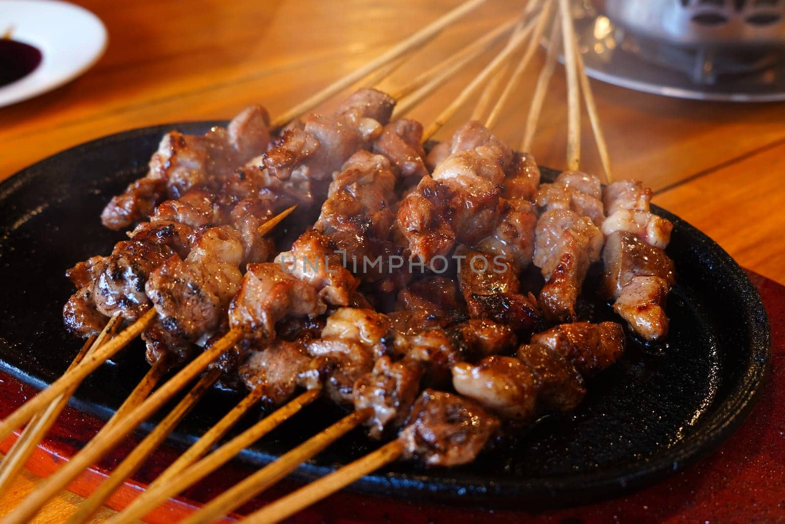 Indonesian lamb satay skewers served on iron hot plate