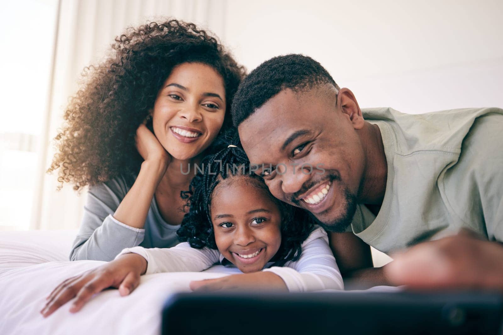 Selfie, smile and black family relax in bed, happy and bonding while posing in their home. Love, girl and parents in a bedroom, resting and having fun, joy and cheerful for photo or profile picture by YuriArcurs