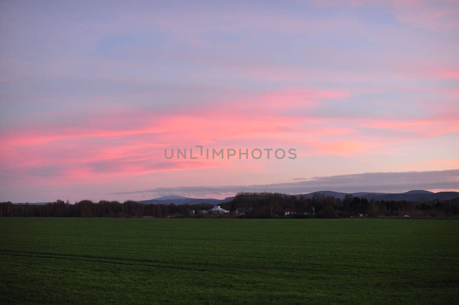 Pink-red sky at sunset over the fields near Bredelem, Langelsheim in Germany