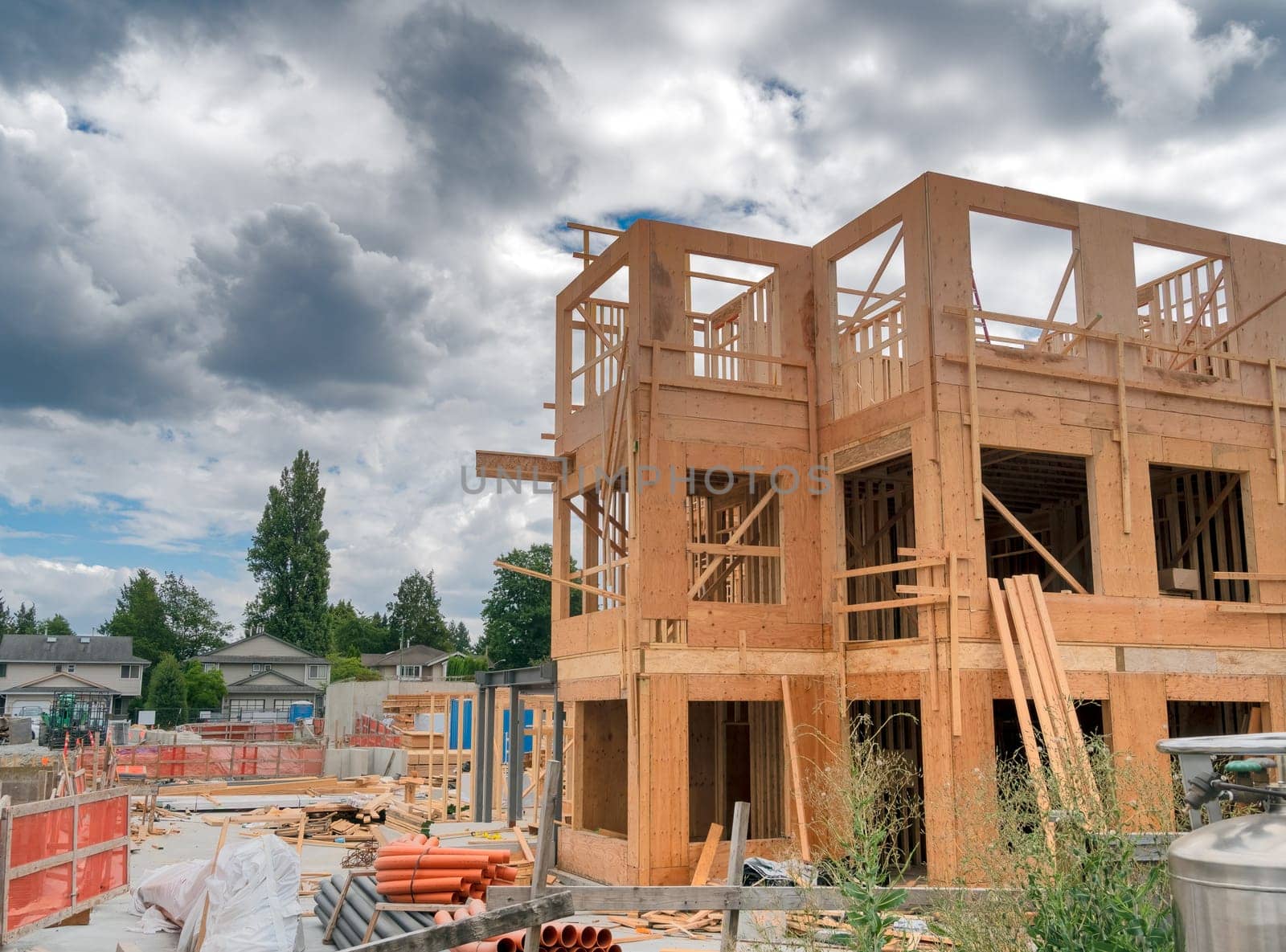 Low-rise residential building under construction on cloudy sky background