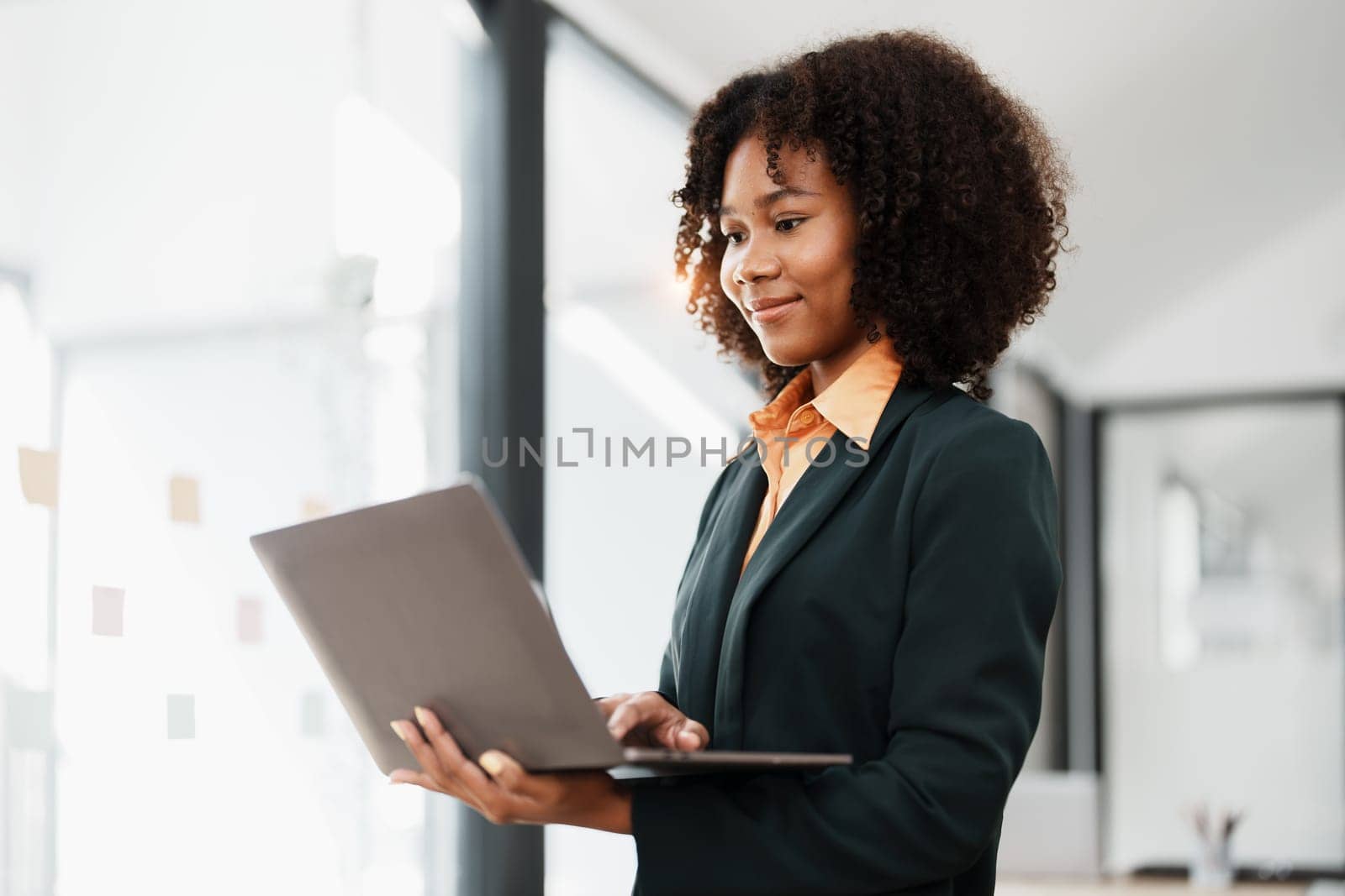 Beautiful young teen American African holding computer laptop with planning working on financial document, tax, exchange, accounting and Financial advisor by Manastrong