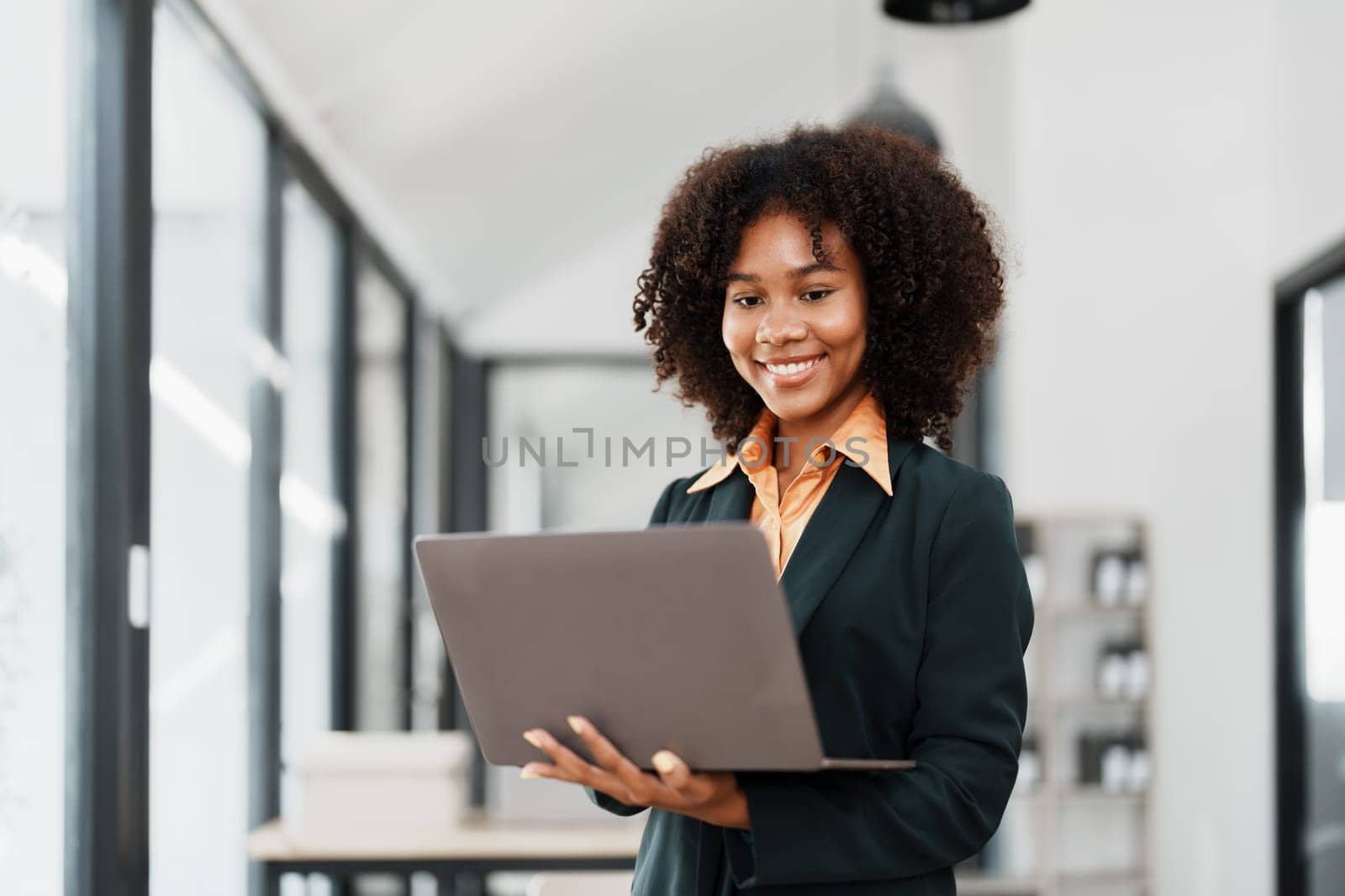 Beautiful young teen American African holding computer laptop with planning working on financial document, tax, exchange, accounting and Financial advisor by Manastrong