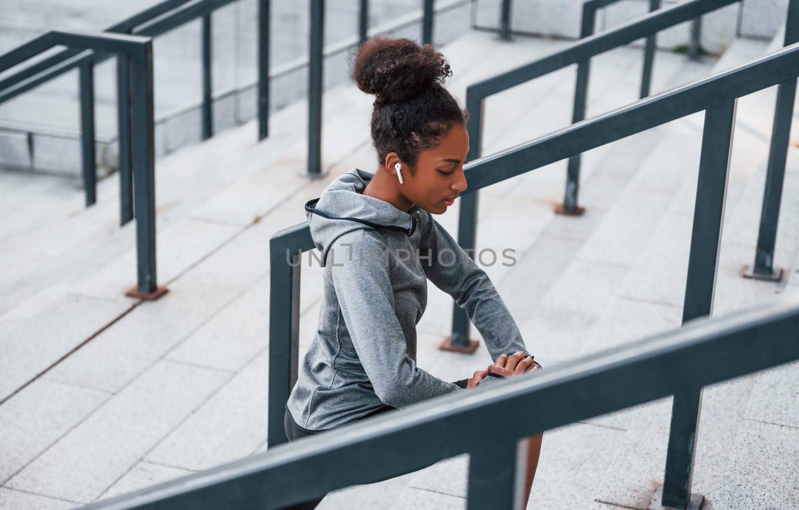 Stretching day. Young african american woman in sportive clothes have workout outdoors by Standret