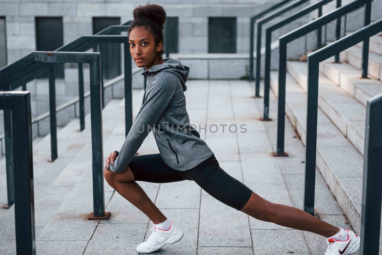 Stretching day. Young african american woman in sportive clothes have workout outdoors by Standret