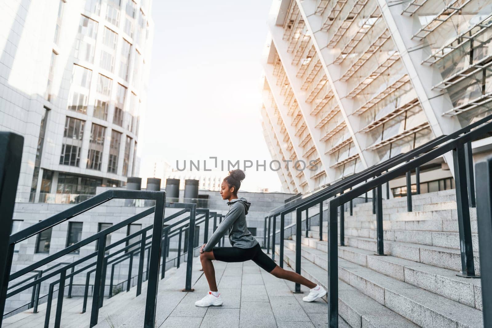 Stretching day. Young african american woman in sportive clothes have workout outdoors.