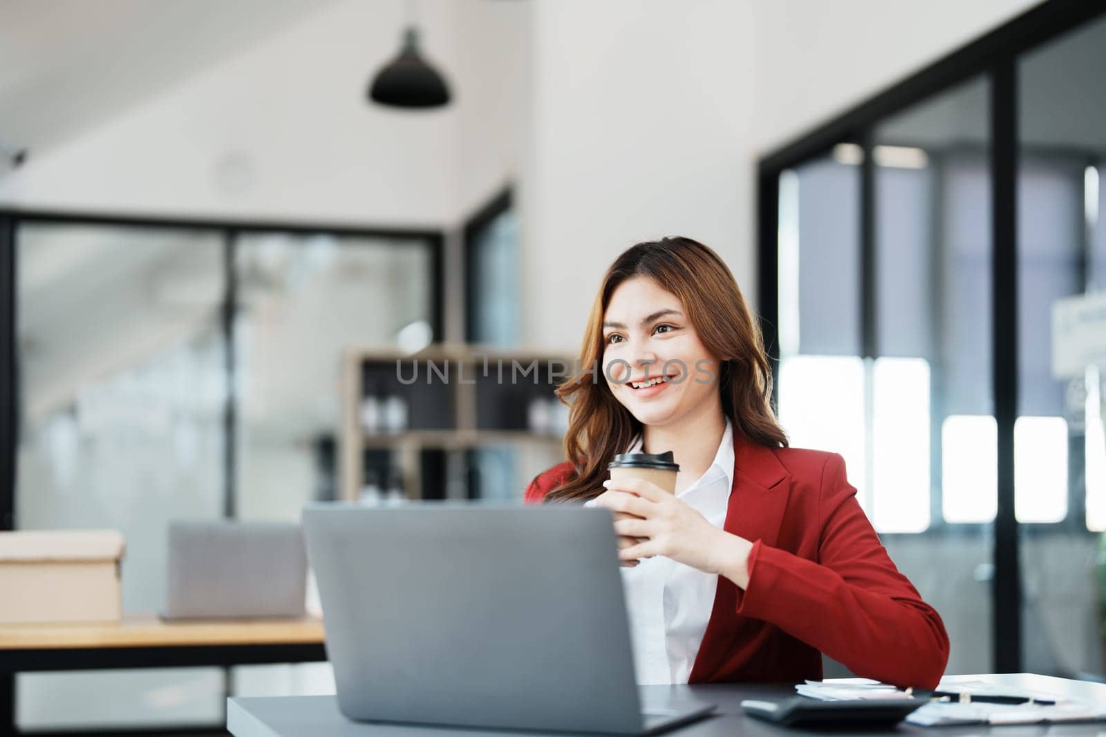 Beautiful young teen asian businesswomen using computer laptop and drink coffee with in smile winner is gesture, Happy to be successful celebrating achievement success.