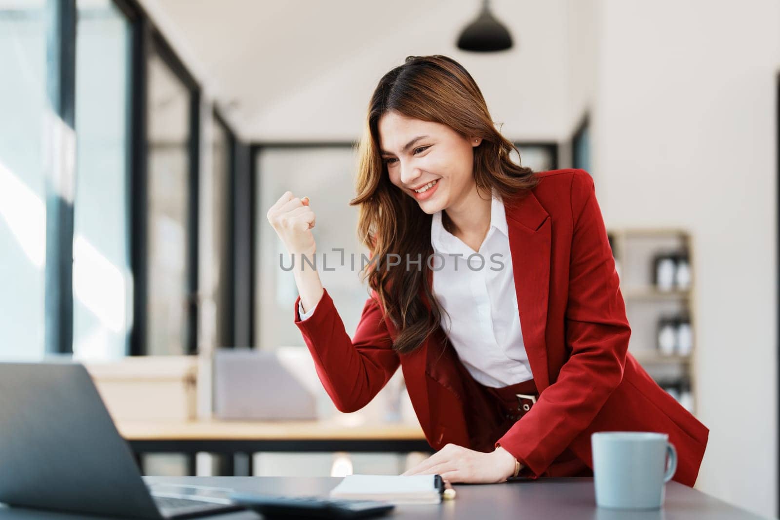Beautiful young teen asian businesswomen using computer laptop with hands up in winner is gesture, Happy to be successful celebrating achievement success.