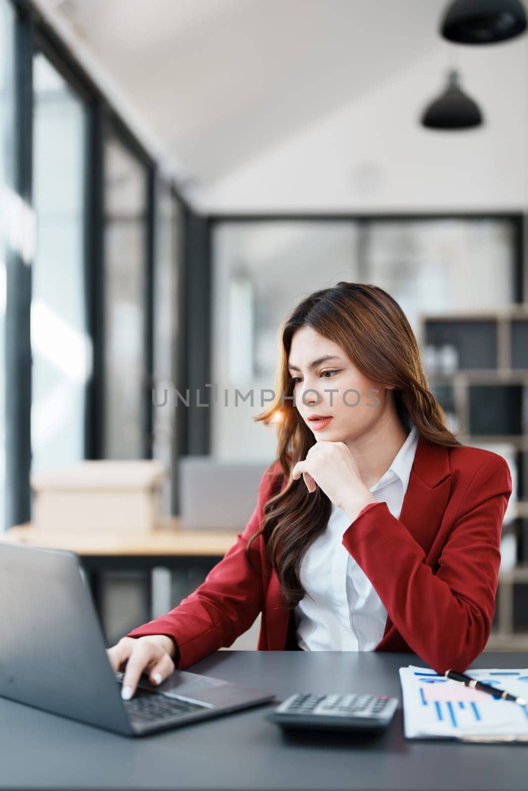 Beautiful young teen asian businesswoman using computer laptop and calculator for calculate with planning working on financial document, tax, exchange, accounting and Financial advisor.