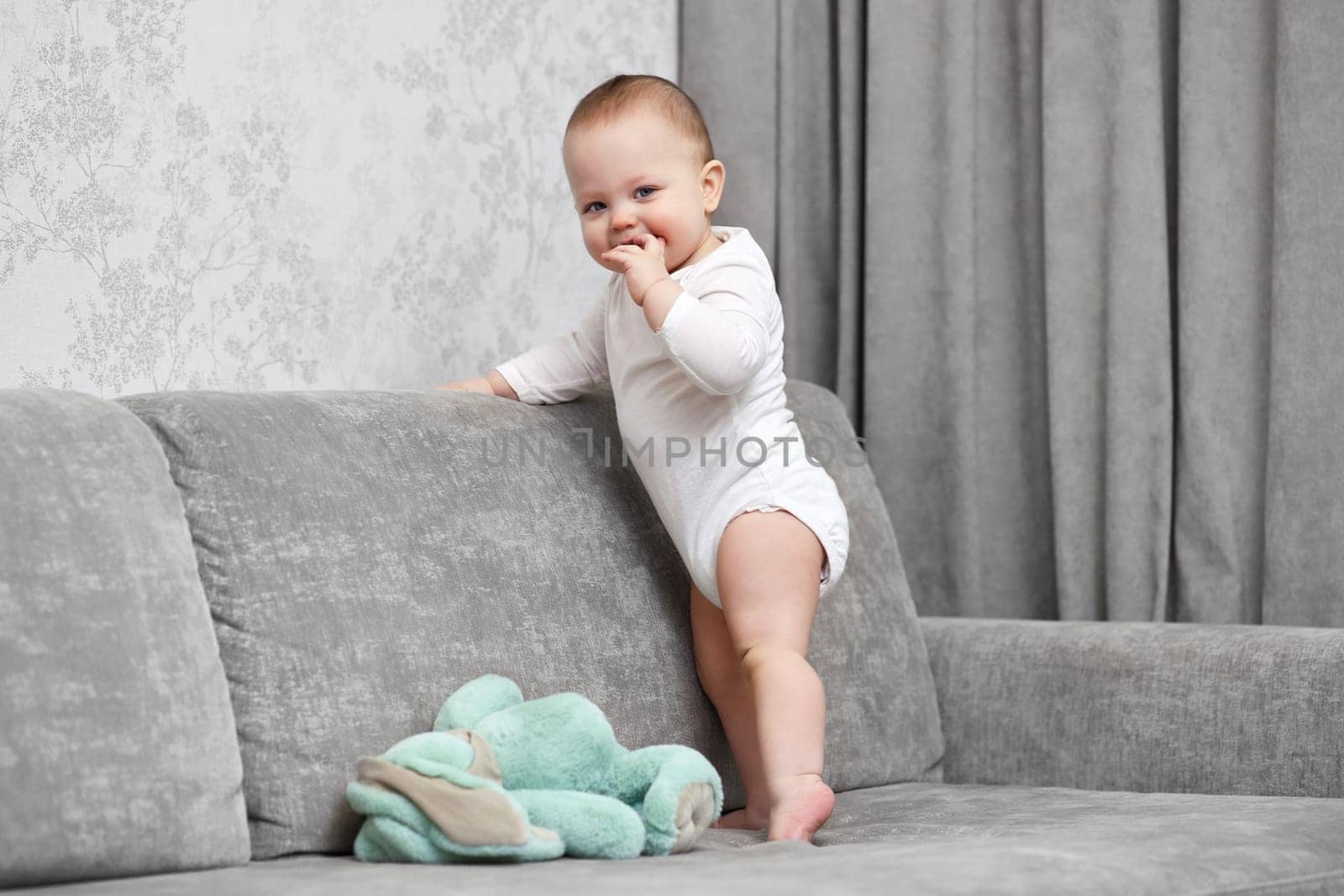 cute baby girl playing with soft toy bunny at home.