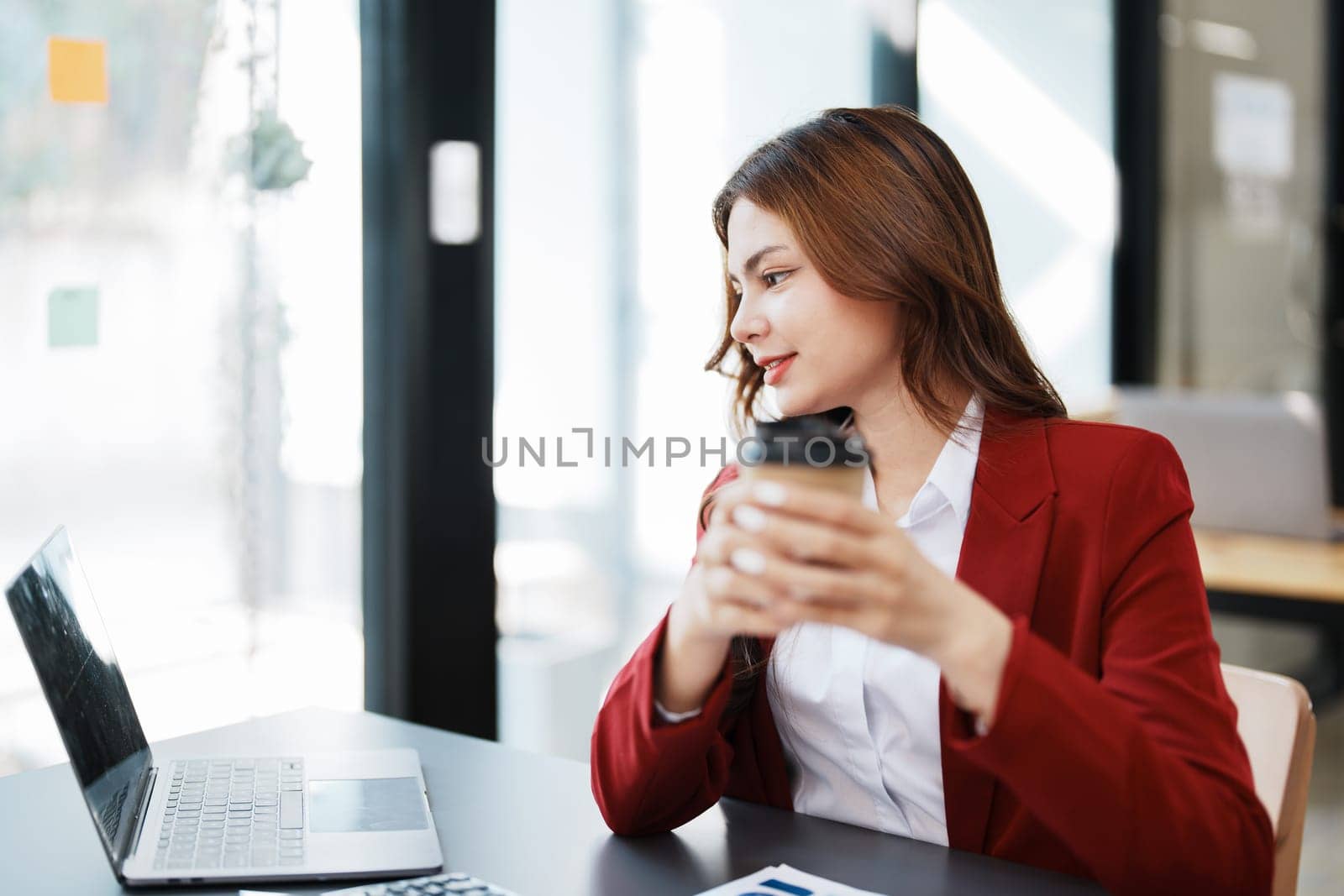 Beautiful young teen asian businesswomen using computer laptop and drink coffee with in smile winner is gesture, Happy to be successful celebrating achievement success.