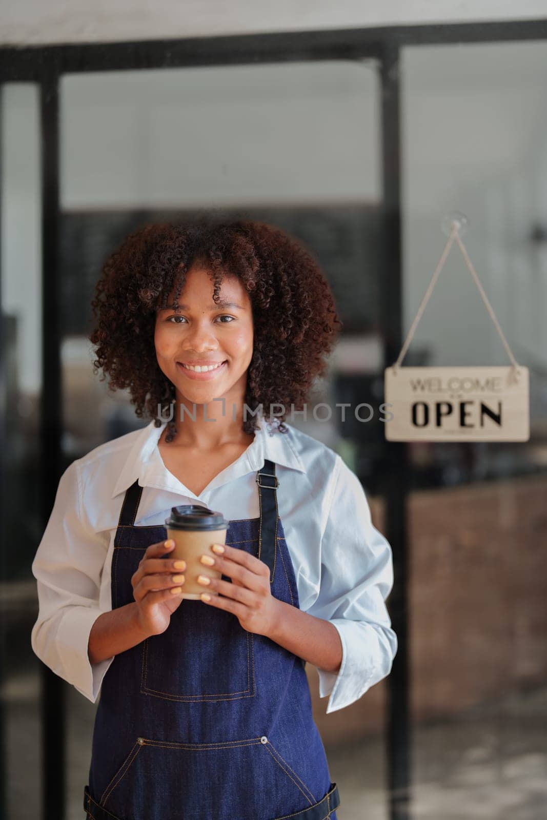 Startup successful small Beautiful American African owner sme beauty girl stand holding coffee cup in coffee shop restaurant, entrepreneur seller business concept by Manastrong
