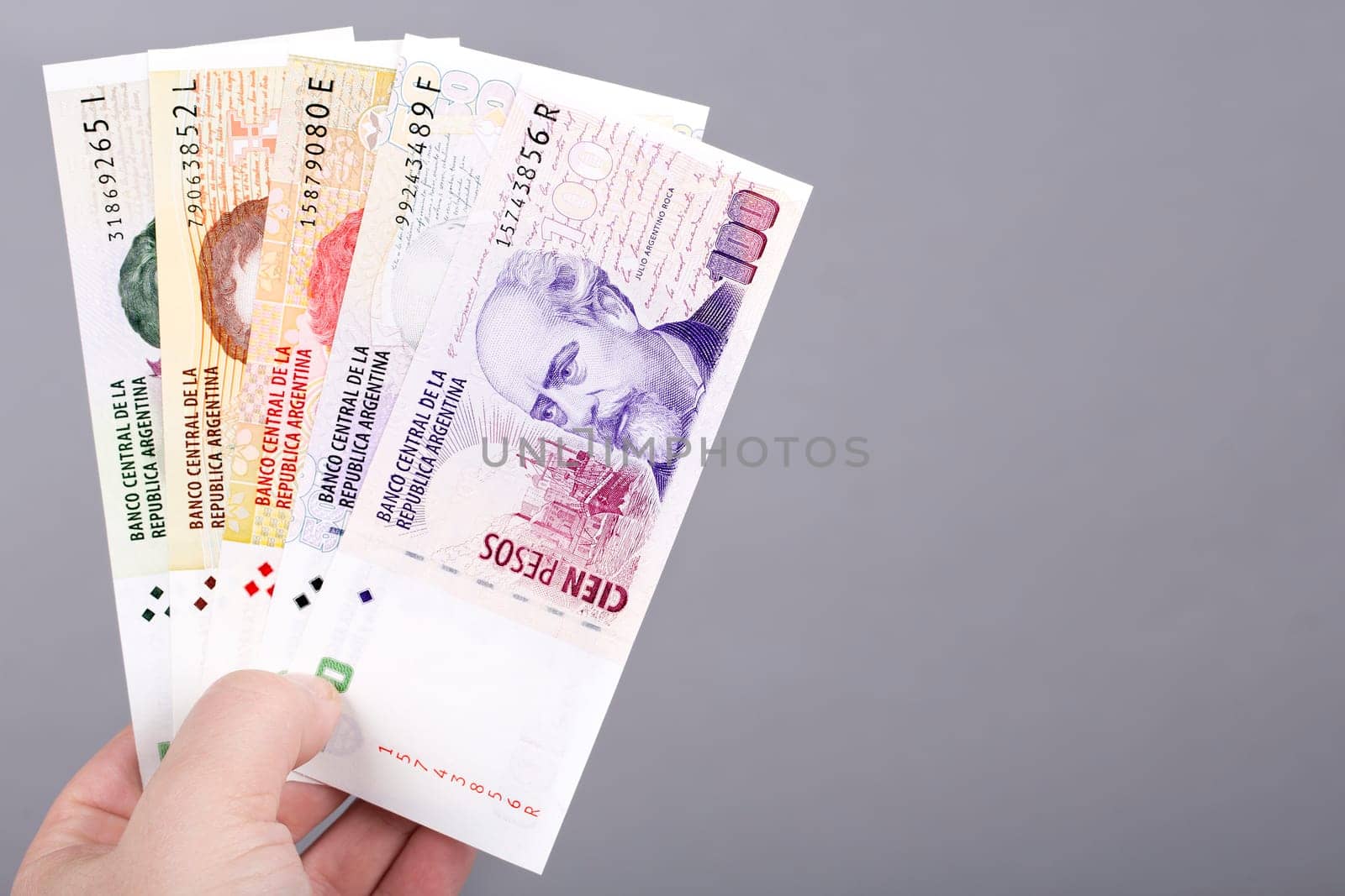 Old Argentine money -  peso  in the hand on a gray background