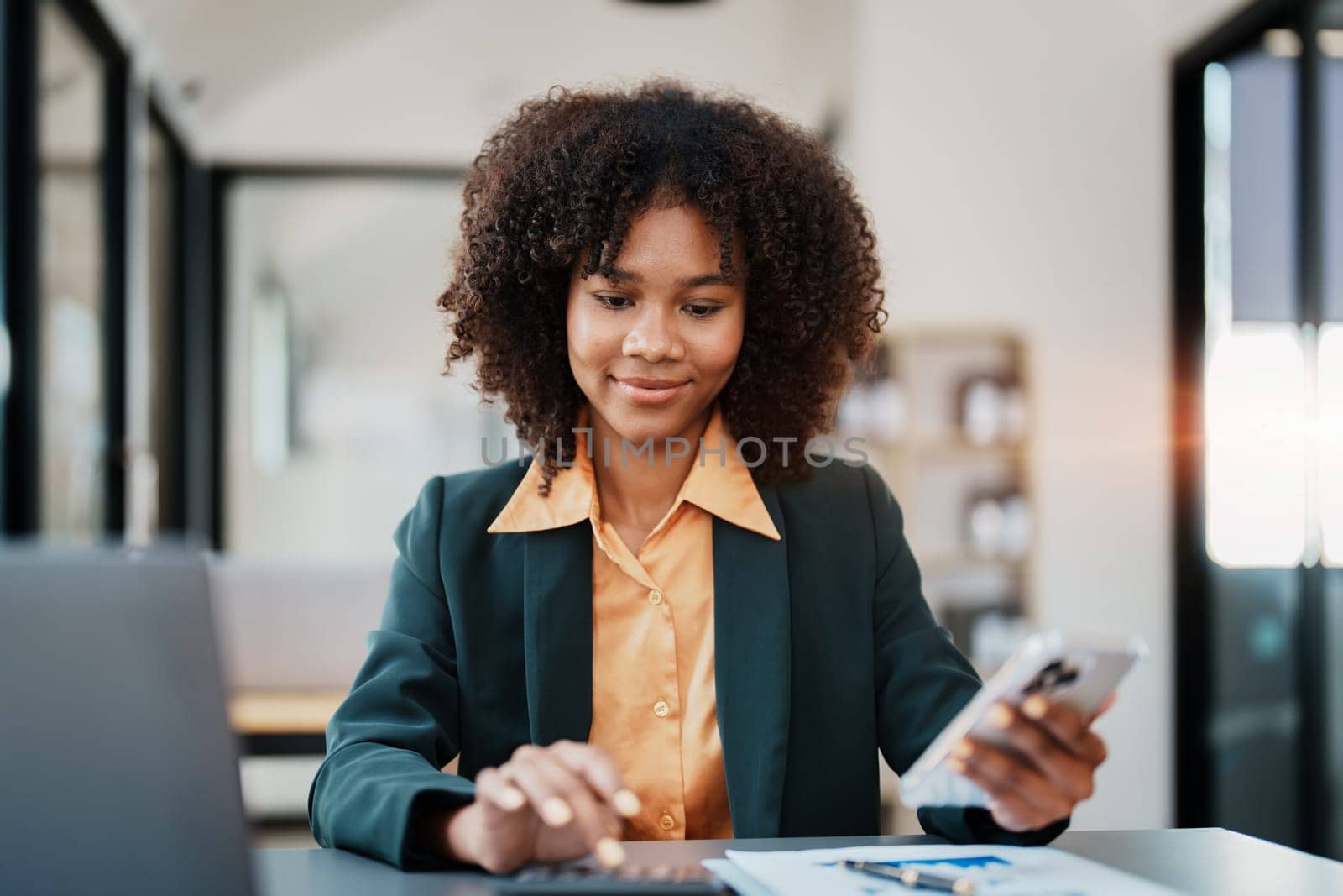 Beautiful young teen American African using calculator for calculating and smart phone mobile with planning working on financial document, tax, exchange, accounting and Financial advisor.