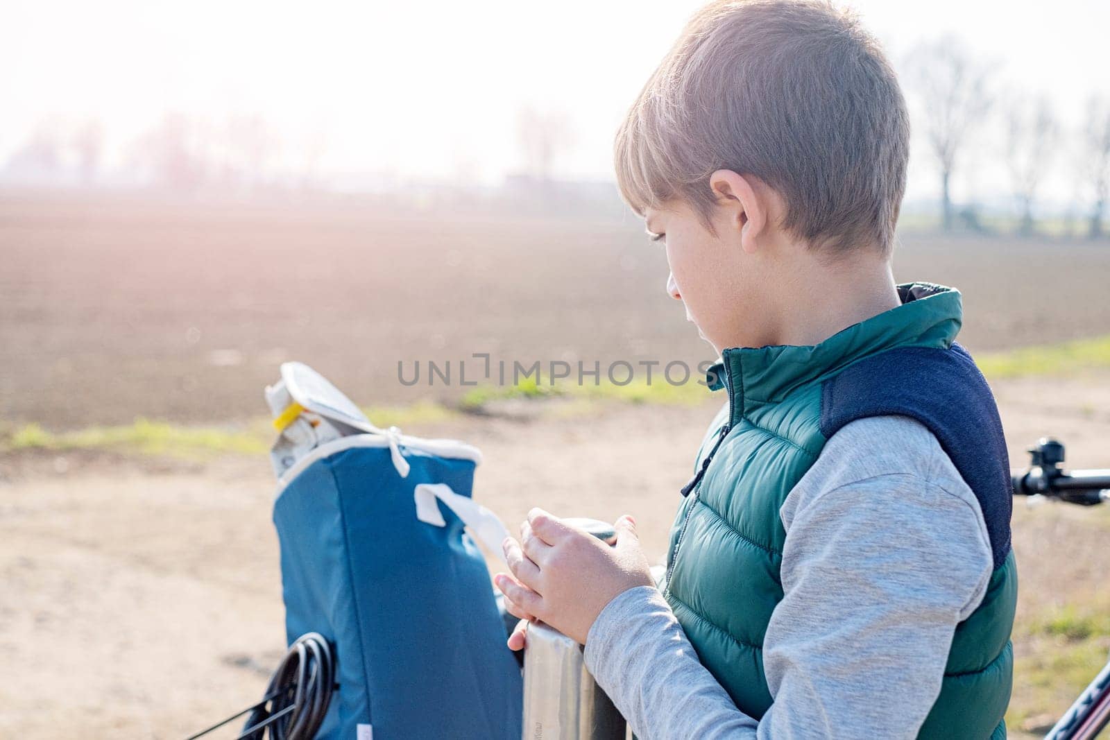 teenager boy with bicycle and bottle of water on sunny day