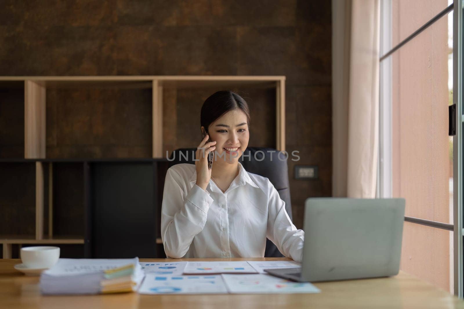 Shot of an attractive young asian businesswoman working on laptop in her workstation.