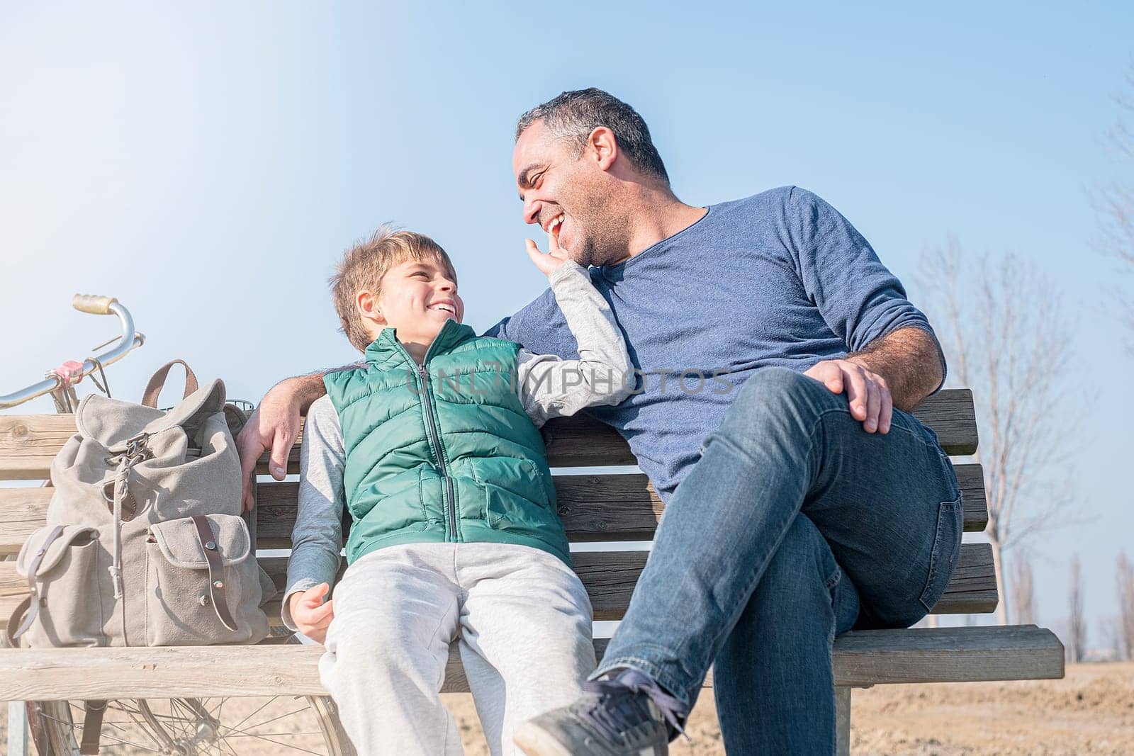 Happy smiling father and son against the blue sky. Family concept