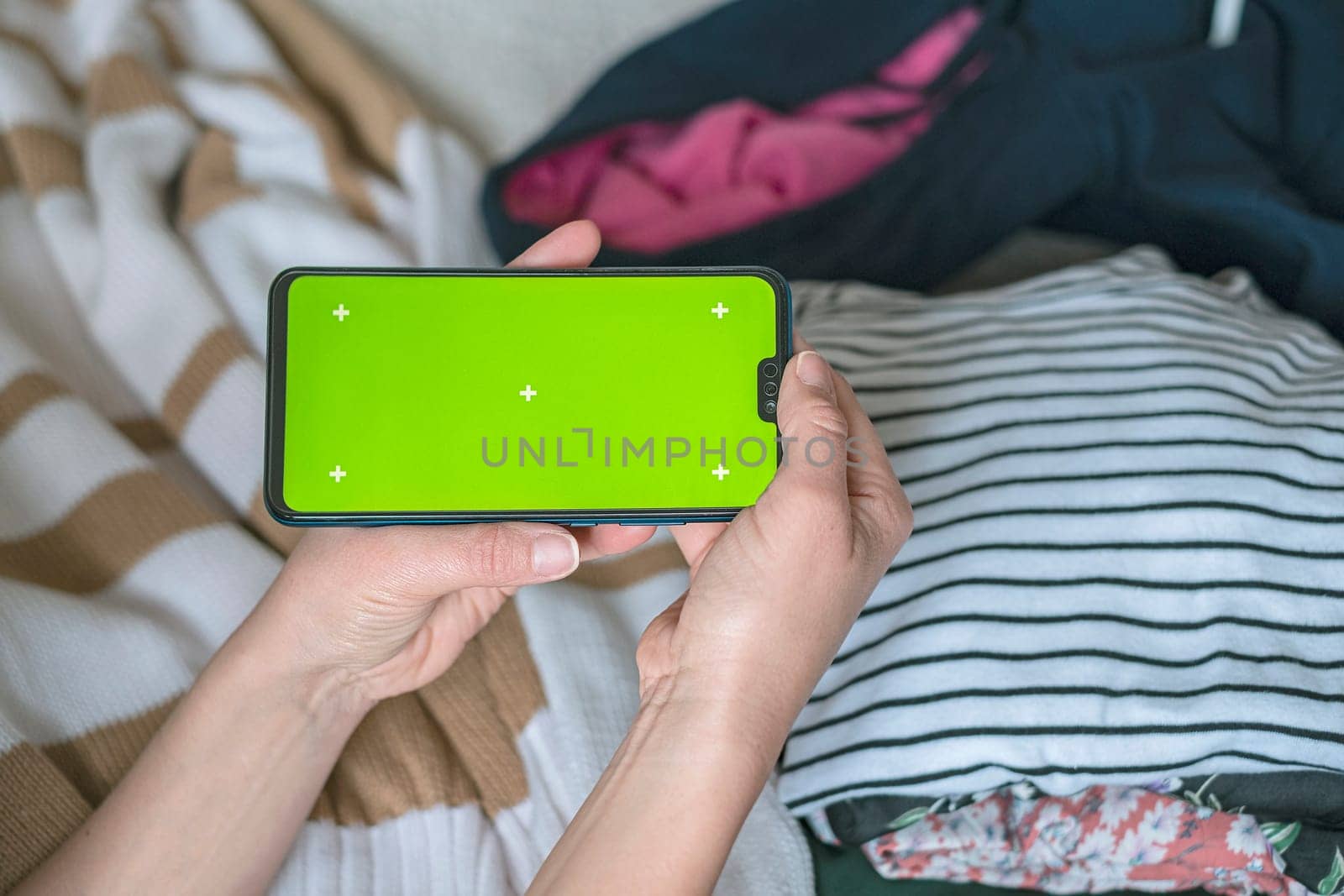 Smartphone with Chroma Key Green Screen close-up. Buying Used Second Hand recycled clothes. Home sale. Recycling Eco New Life, European Store.