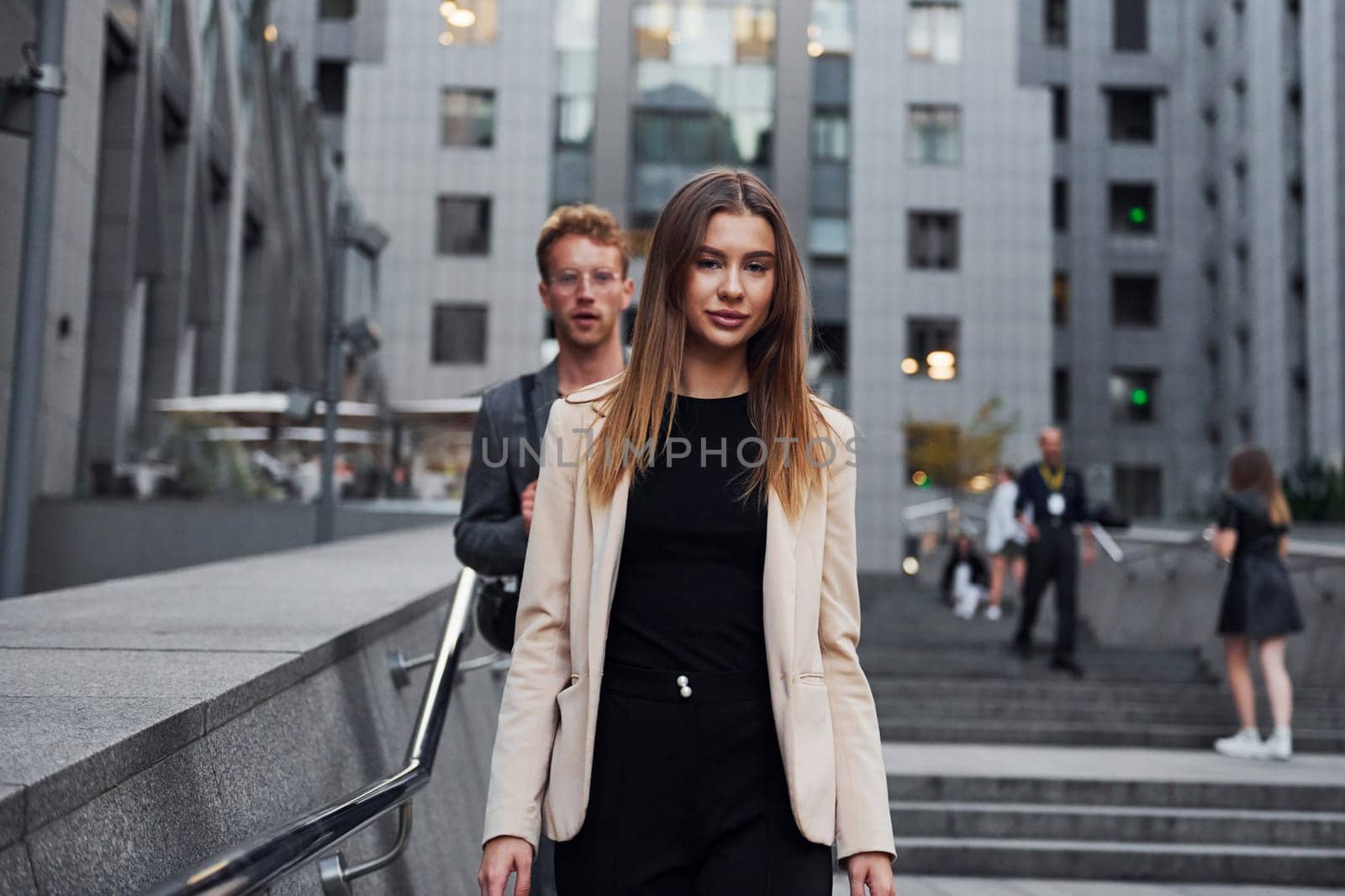 Woman and man in the town at daytime. Well dressed people.