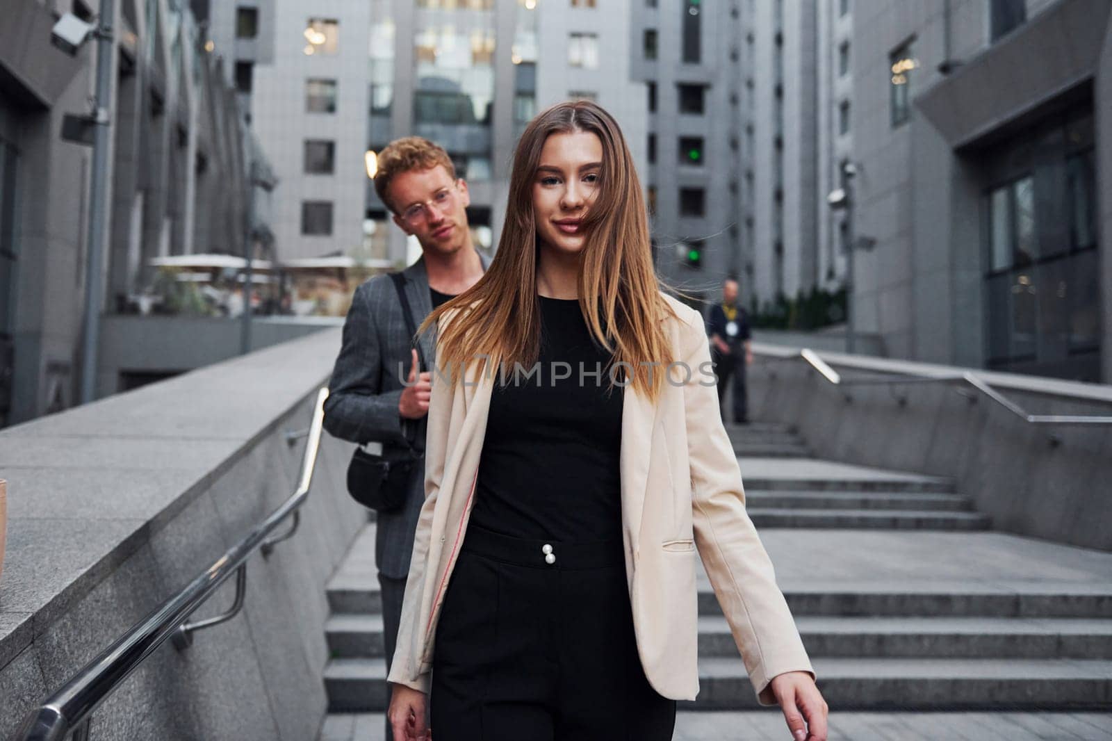 Woman and man in the town at daytime. Well dressed people.