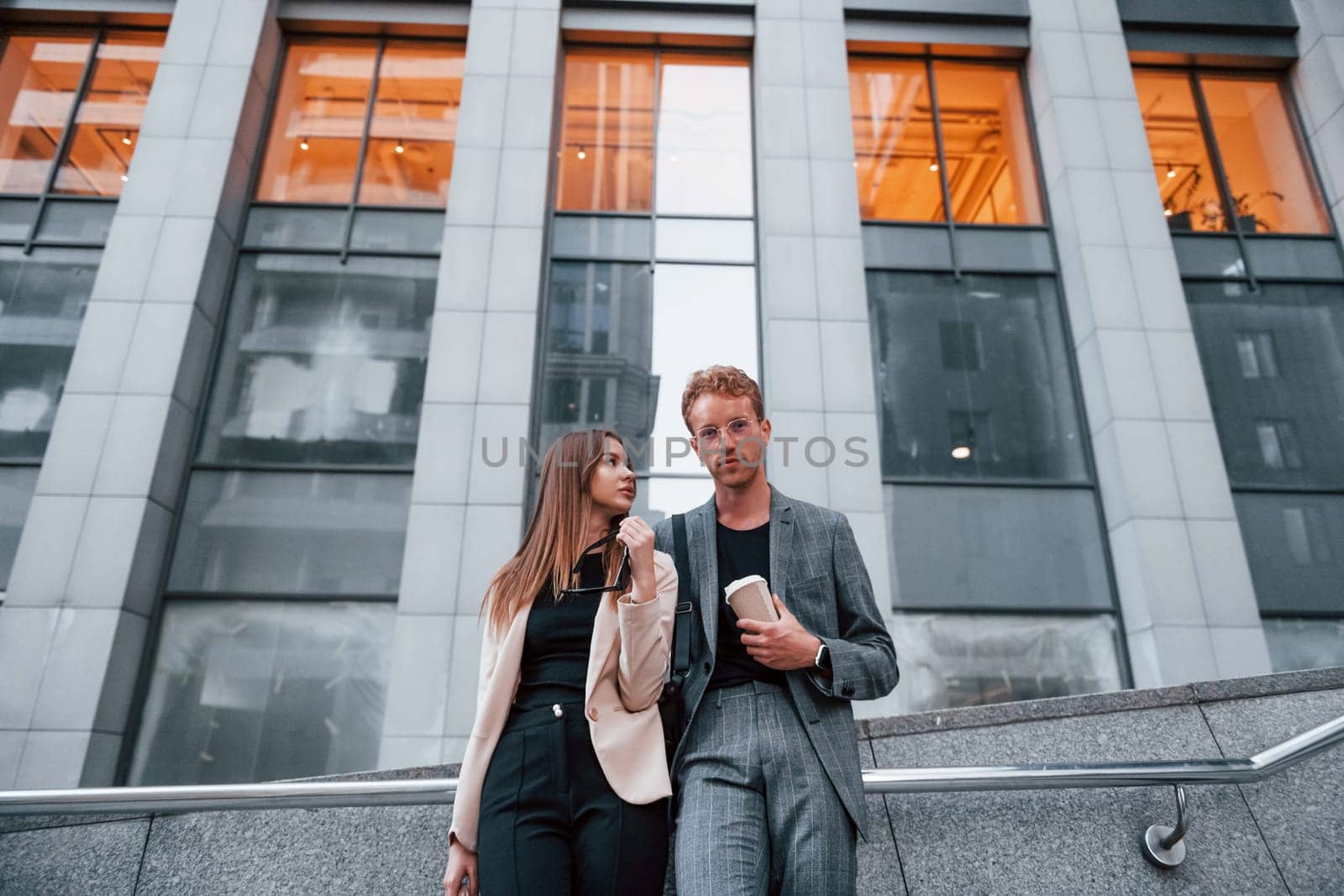 Woman and man in the town at daytime. Well dressed people.